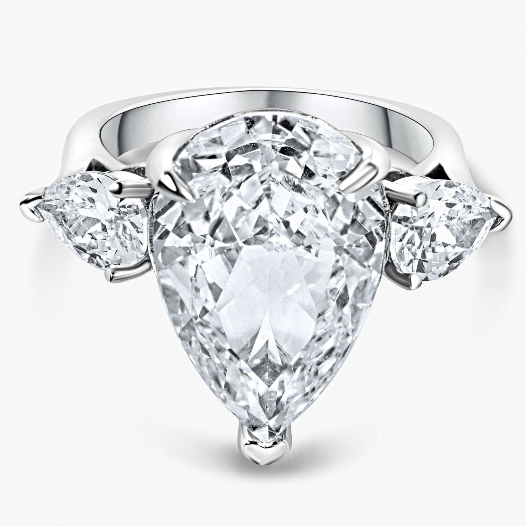 Diamond ring with a pear-shaped center stone and two side stones on a white background