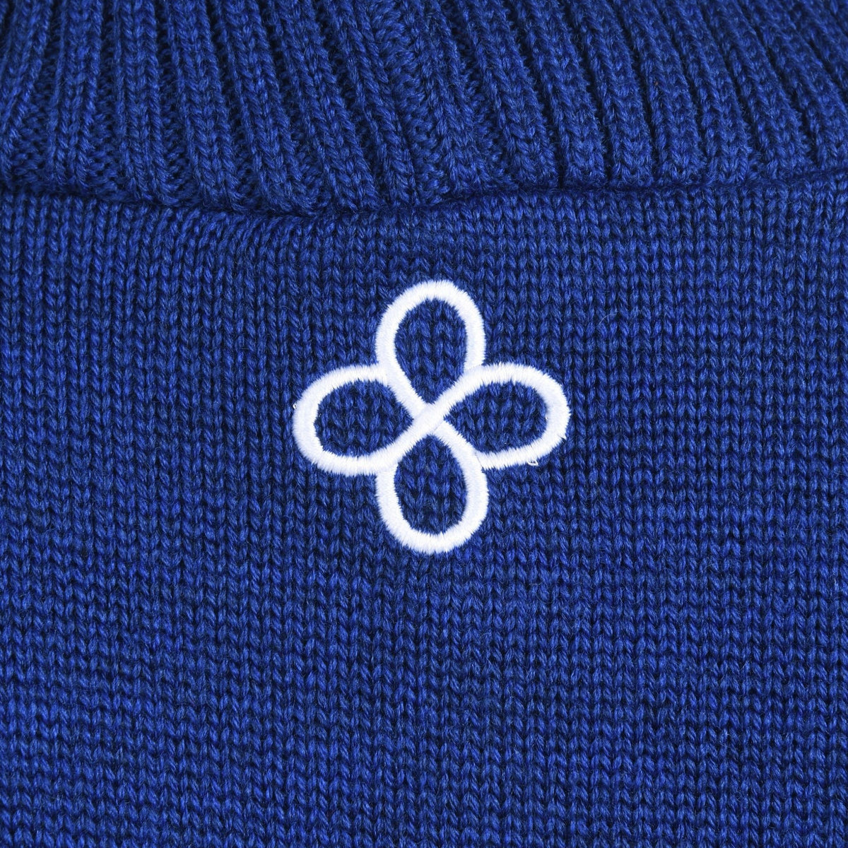 Close-up of a blue fabric with a white embroidered logo