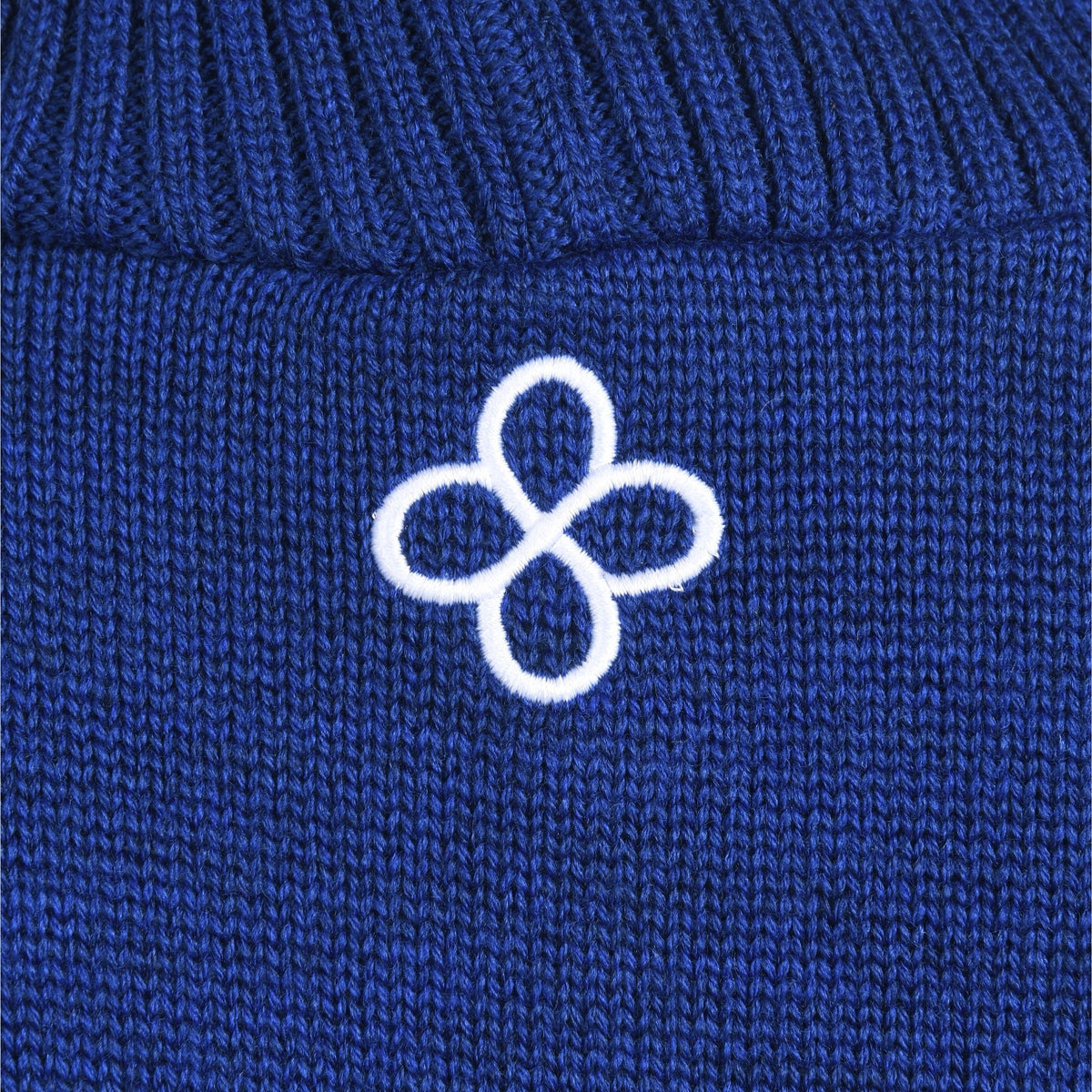 Close-up of a blue fabric with a white embroidered logo