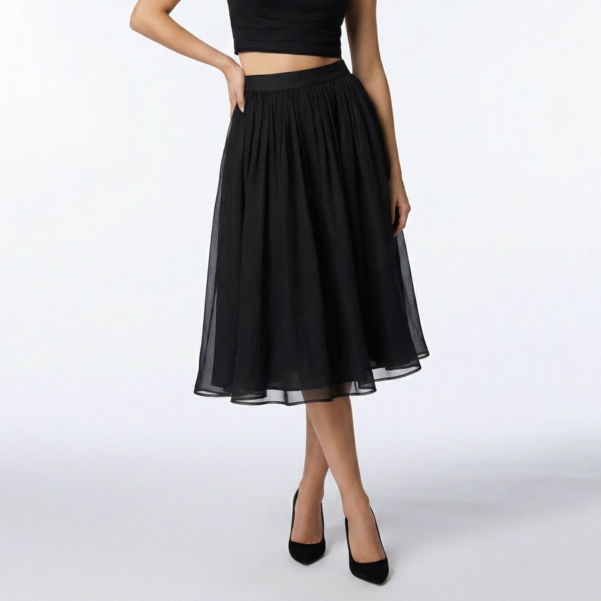 Black skirt worn by a person on a white background