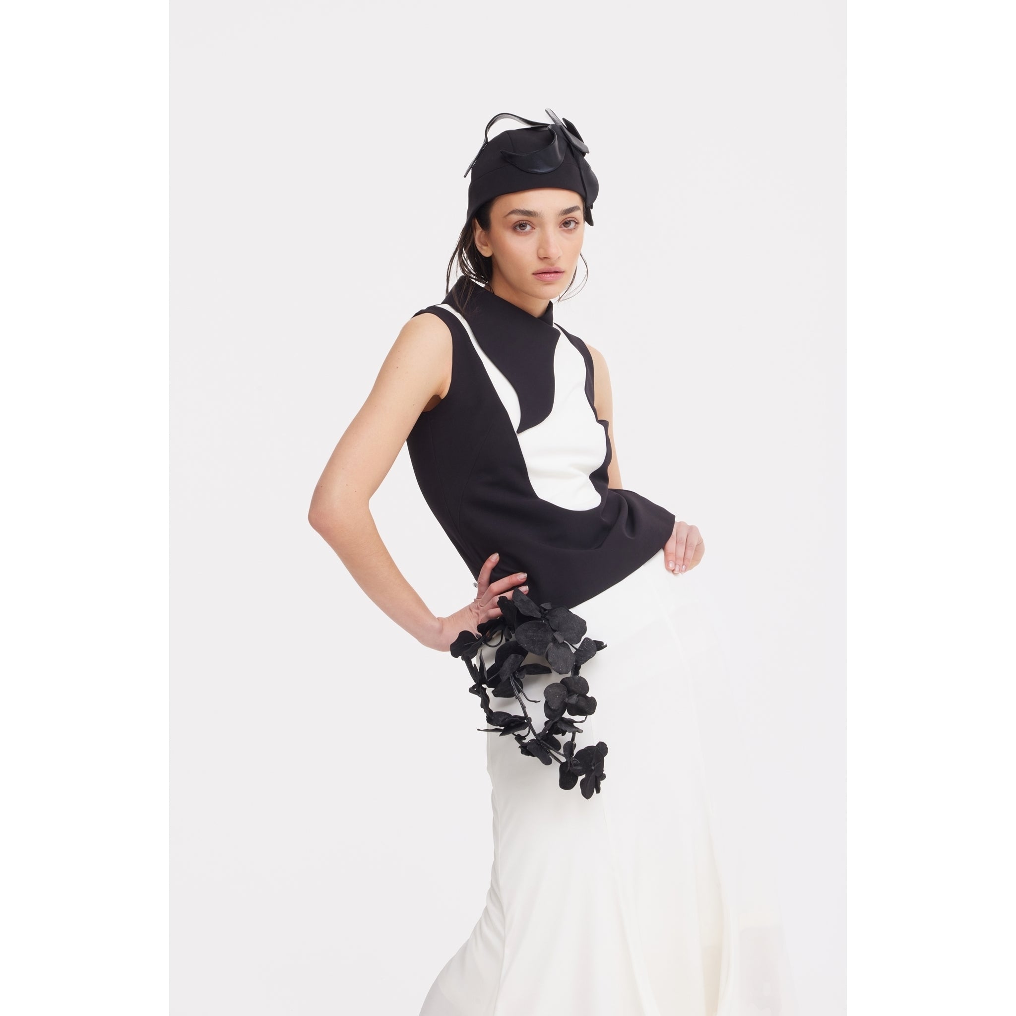 A woman models the JULIA ALLERT High Waist Double-Sided Satin Maxi Skirt in ivory, styled elegantly with a black bow headpiece against a plain white background.