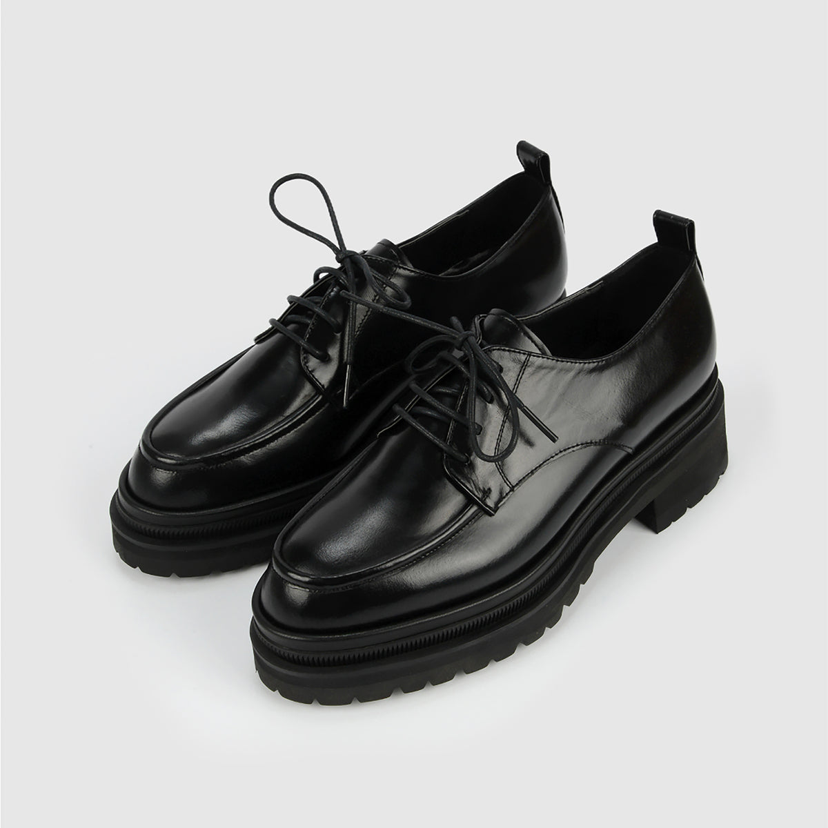 A pair of THEN Black Chunky Leather Derby Shoes with Lug Sole, handcrafted in Korea, is displayed on a plain light gray background.