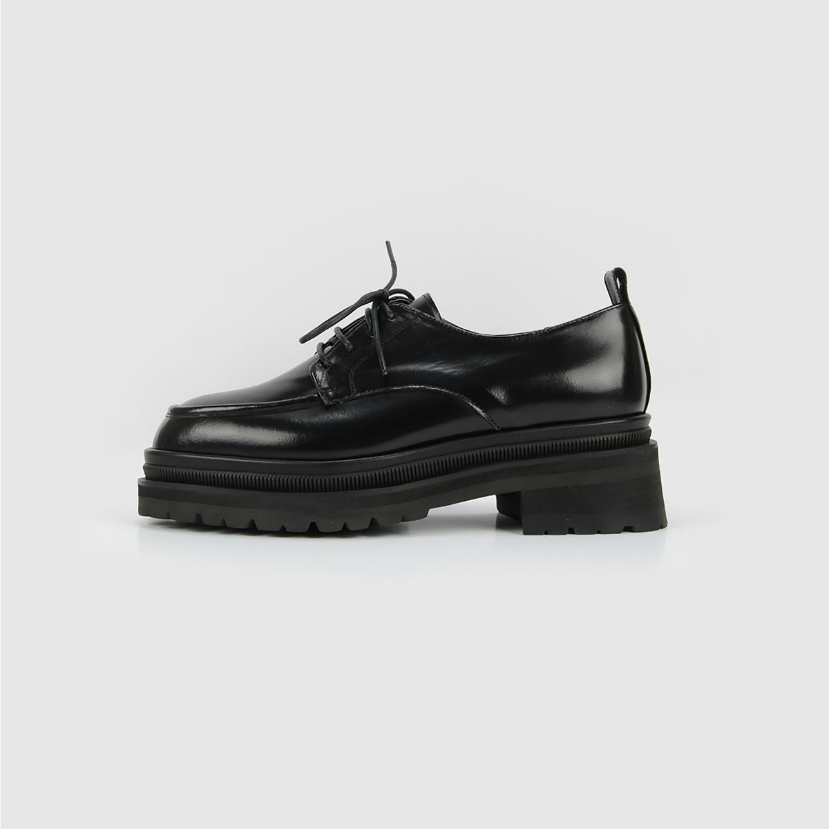 The THEN Black Chunky Leather Derby Shoes with Lug Sole feature a shiny finish, lace-up front, chunky lug sole, and low block heel, handcrafted in Korea and shown in profile against a plain white background.
