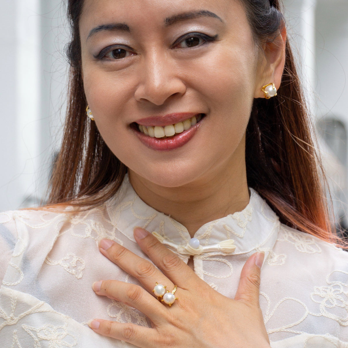 Woman wearing pearl jewelry with a blurred background