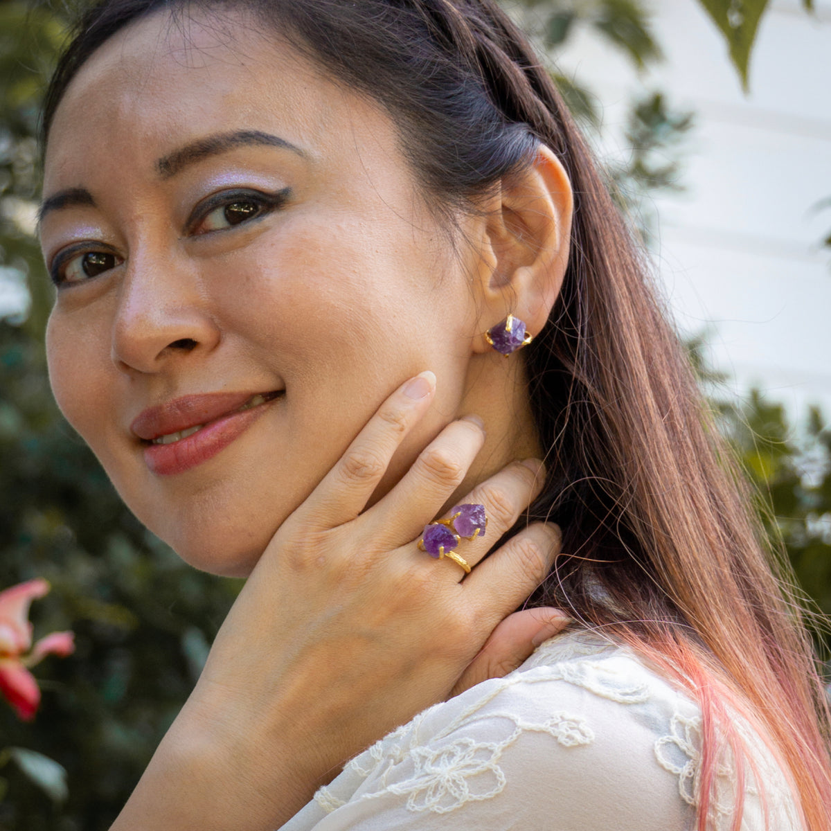Woman wearing purple gemstone jewelry outdoors