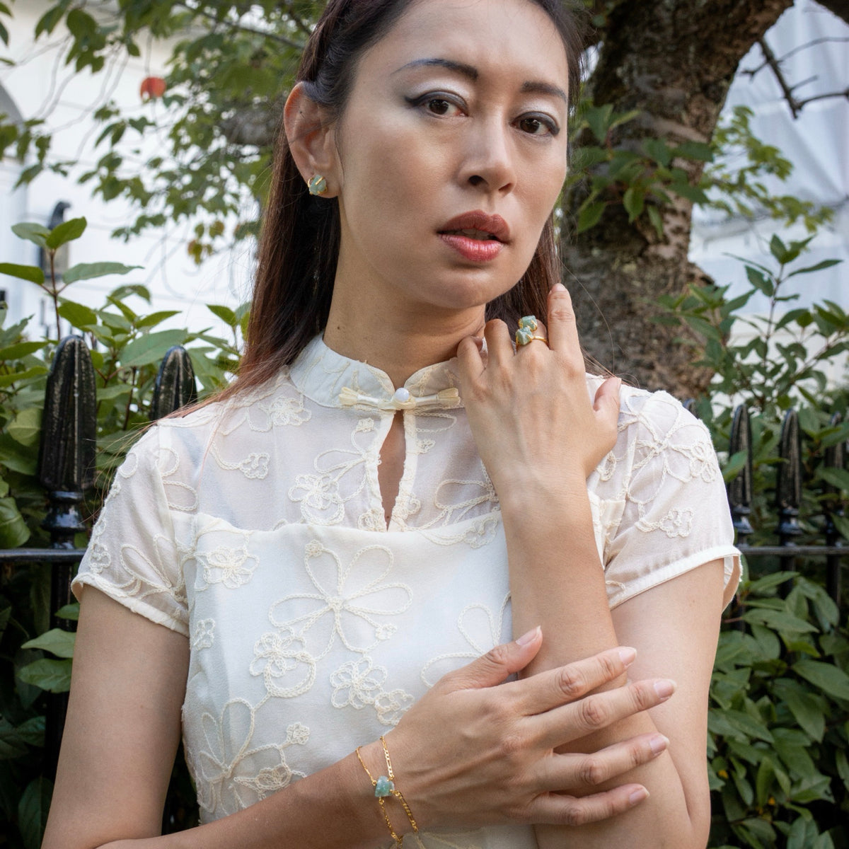 Woman wearing a white lace top with jewelry outdoors