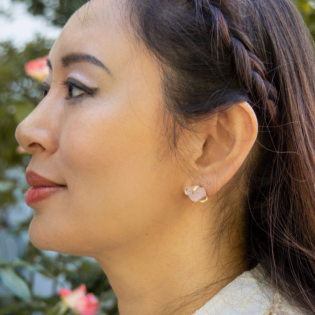 Close-up of a woman wearing a floral earring with a blurred natural background