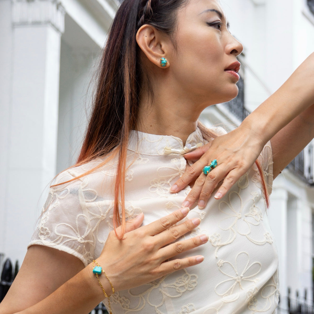 Woman wearing a white lace dress with turquoise jewelry outdoors