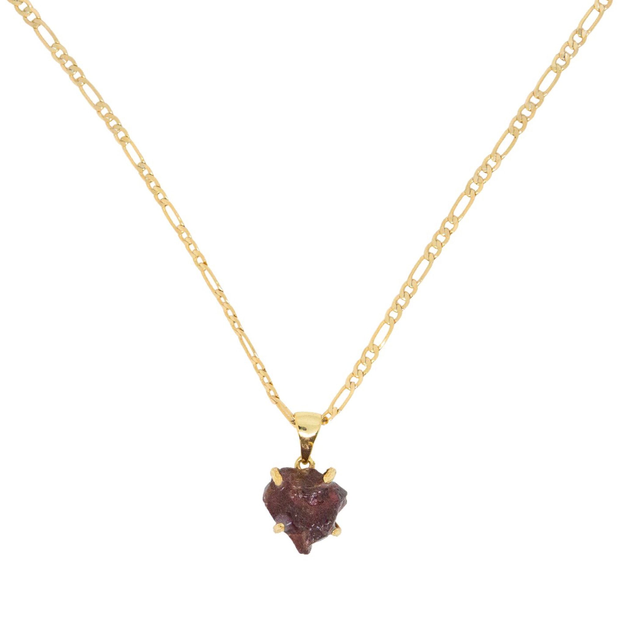 Gold necklace with a heart-shaped dark red stone pendant on a white background