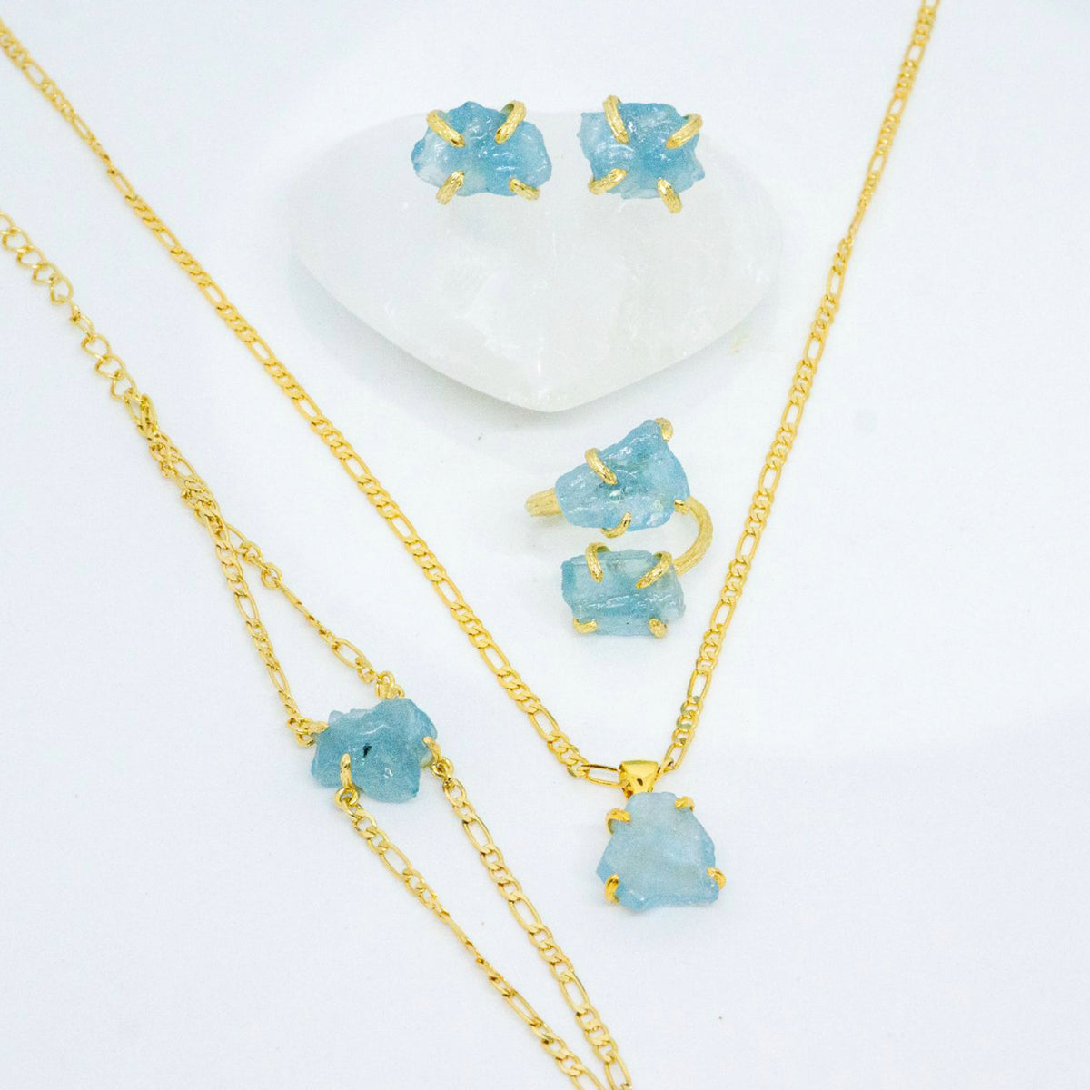 Gold jewelry set with blue gemstones on a white background