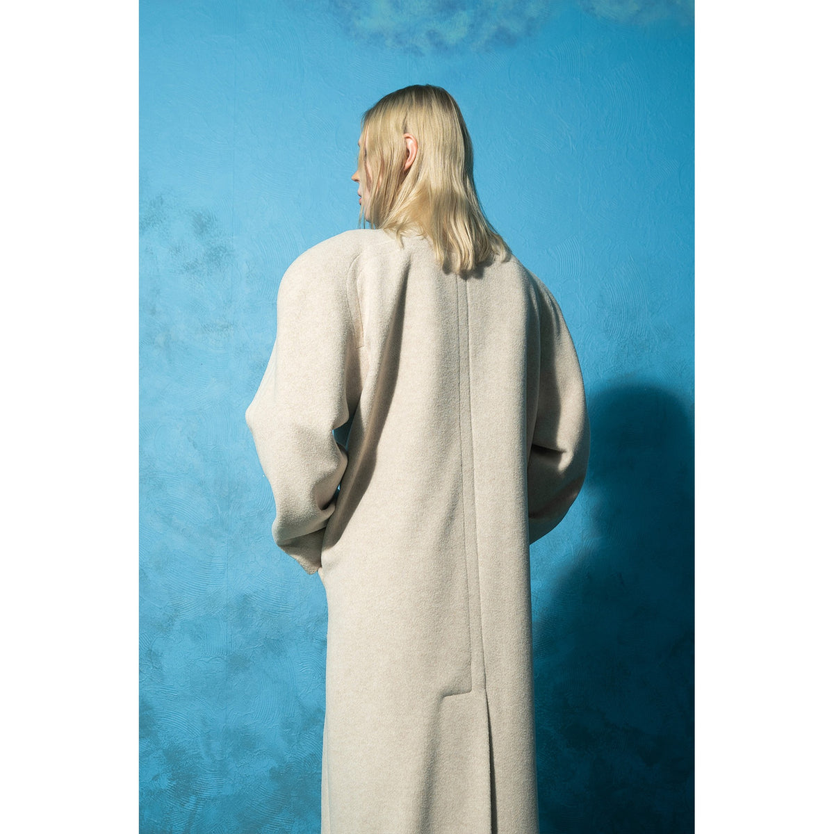 Model wearing beige wool-blend maxi coat with vintage buttons by MASHAT