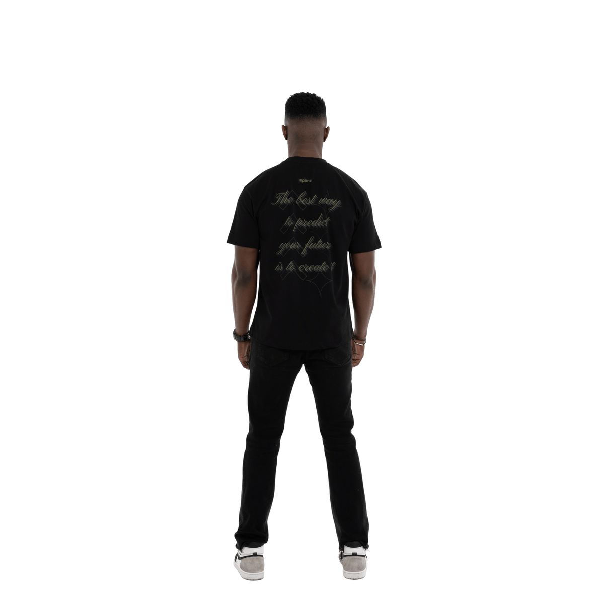 Person wearing a black t-shirt with text on the back, standing against a white background