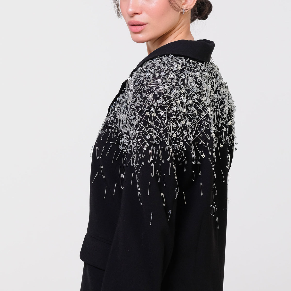 Black garment with silver embellishments on a plain background