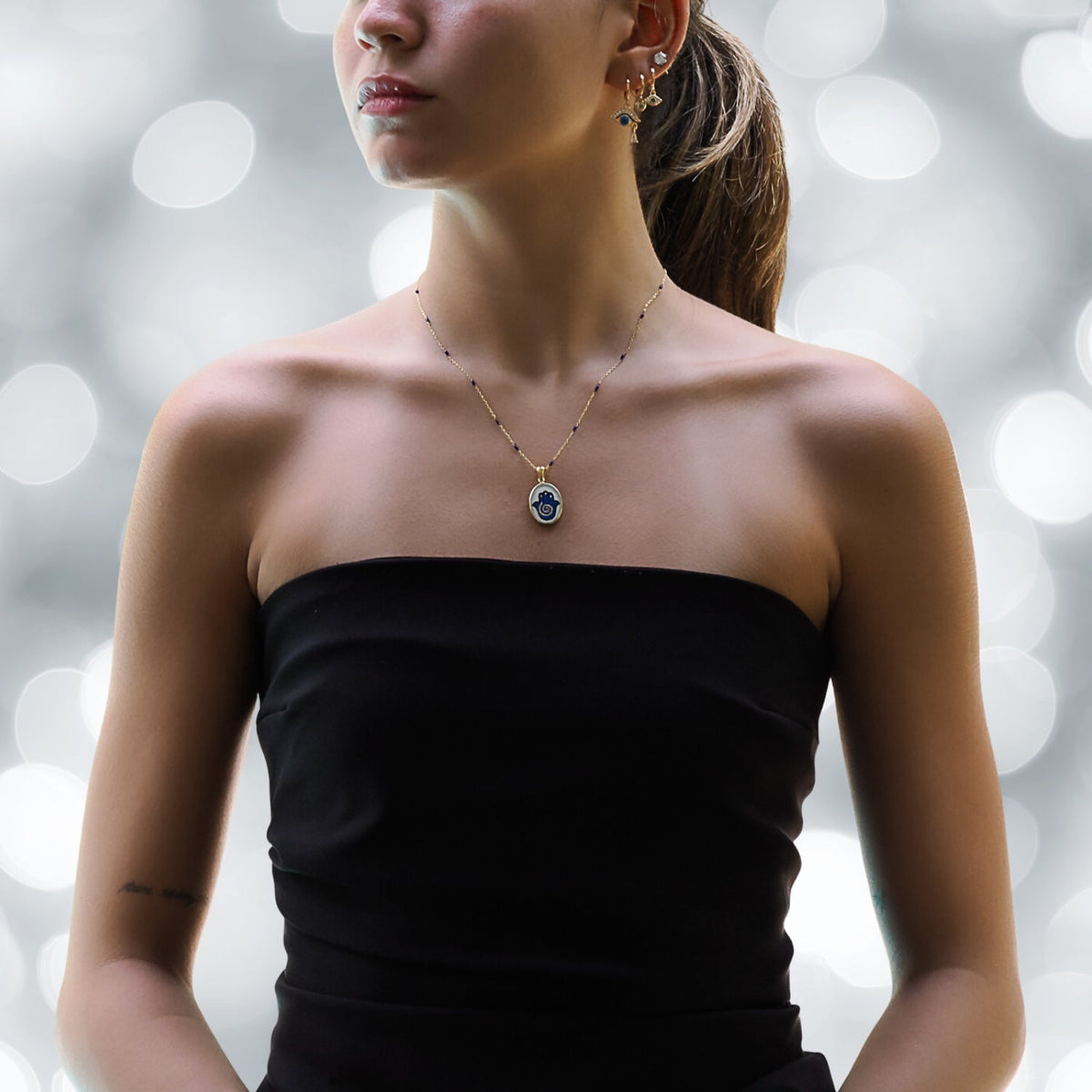 Model Sporting an Elegant Hamsa Hand Pendant Necklace with Blue Enamel.