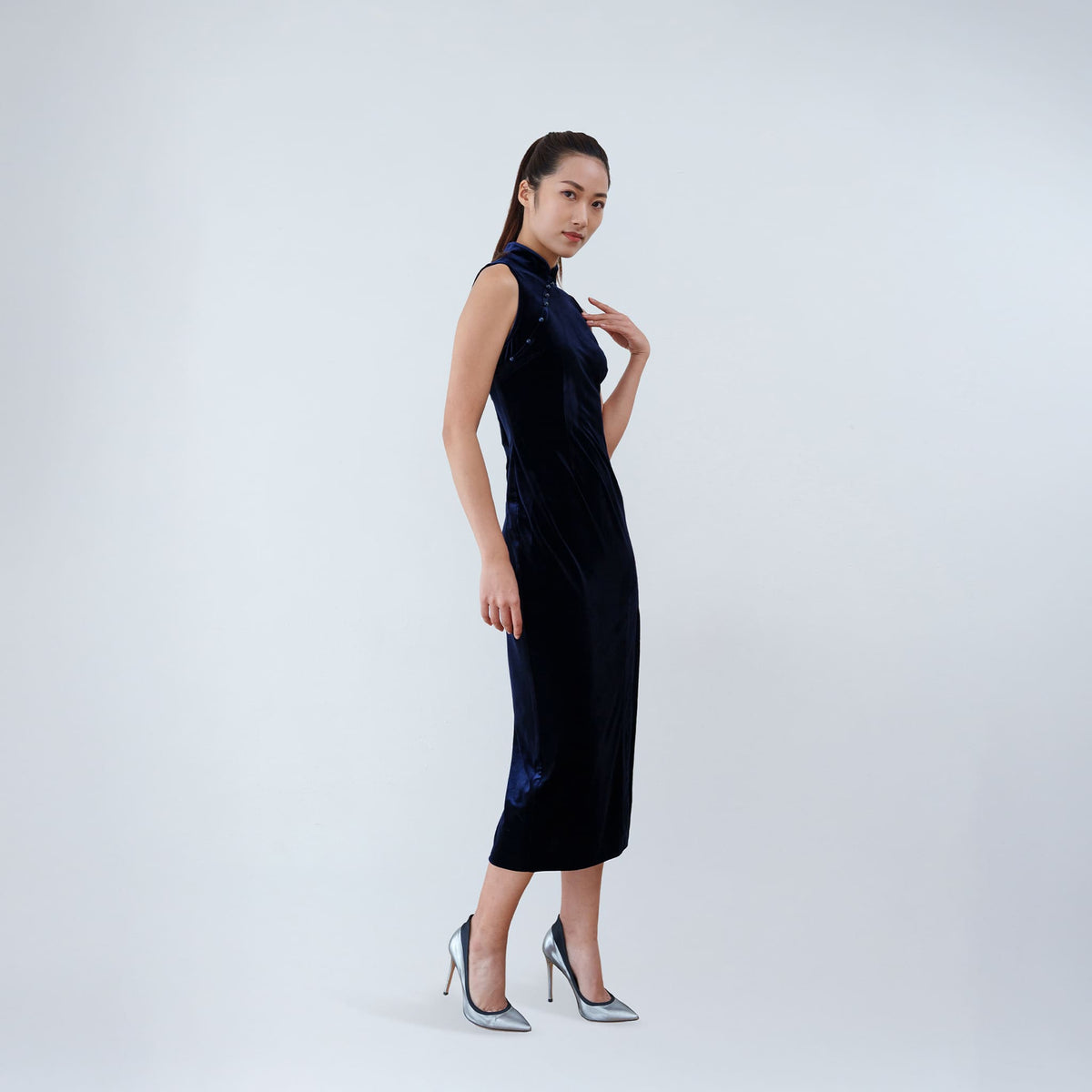 Qipology navy blue velvet sleeveless qipao dress with Mandarin collar, beaded detail and front slit, worn by model, look 3, buy at DOORS NYC