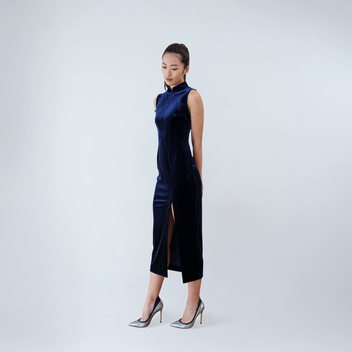 Qipology navy blue velvet sleeveless qipao dress with Mandarin collar, beaded detail and front slit, worn by model, look 4, buy at DOORS NYC