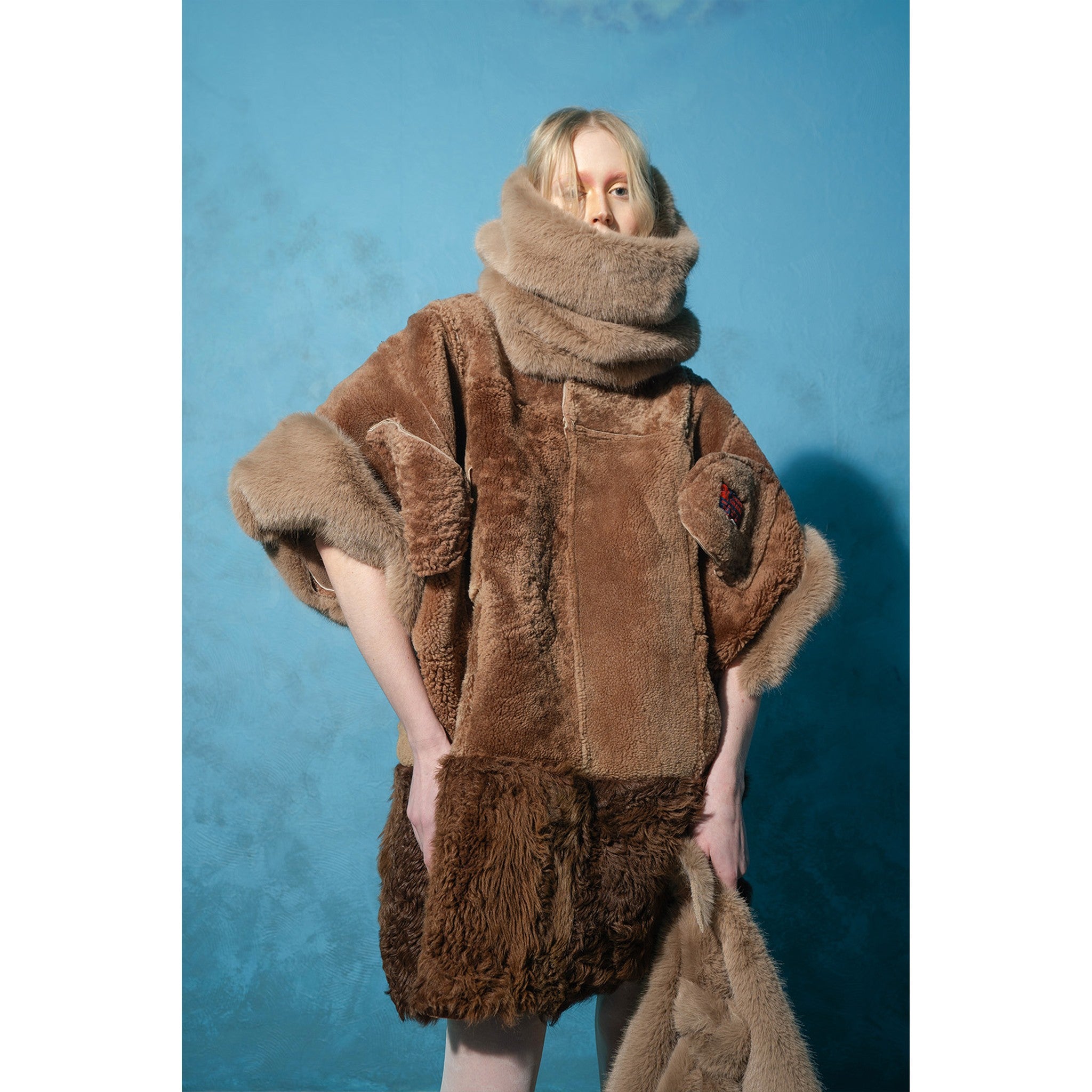 Model wearing brown and mint reversible faux fur jacket by MASHAT