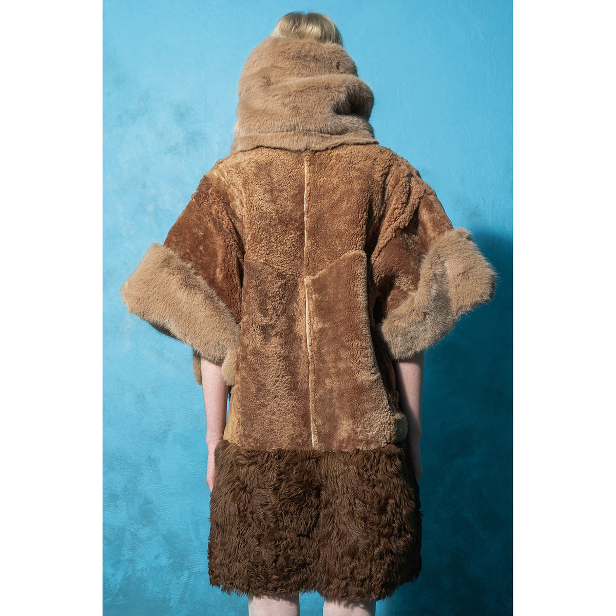 Model wearing brown and mint reversible faux fur jacket by MASHAT