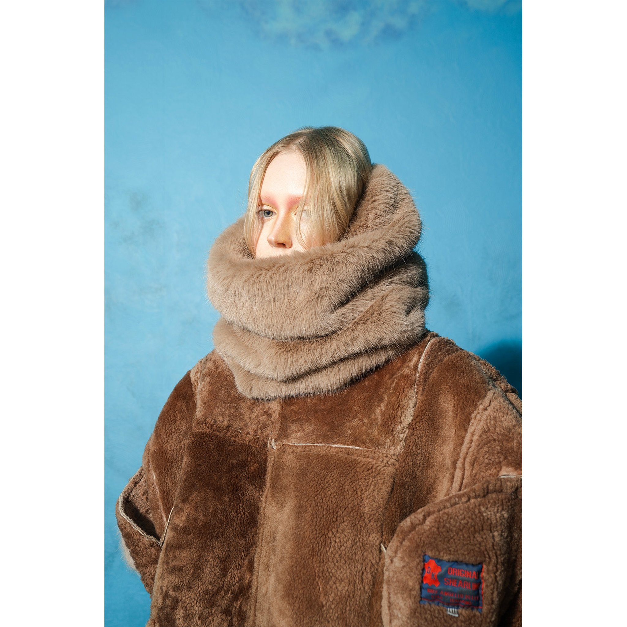 Model wearing brown and mint reversible faux fur jacket by MASHAT