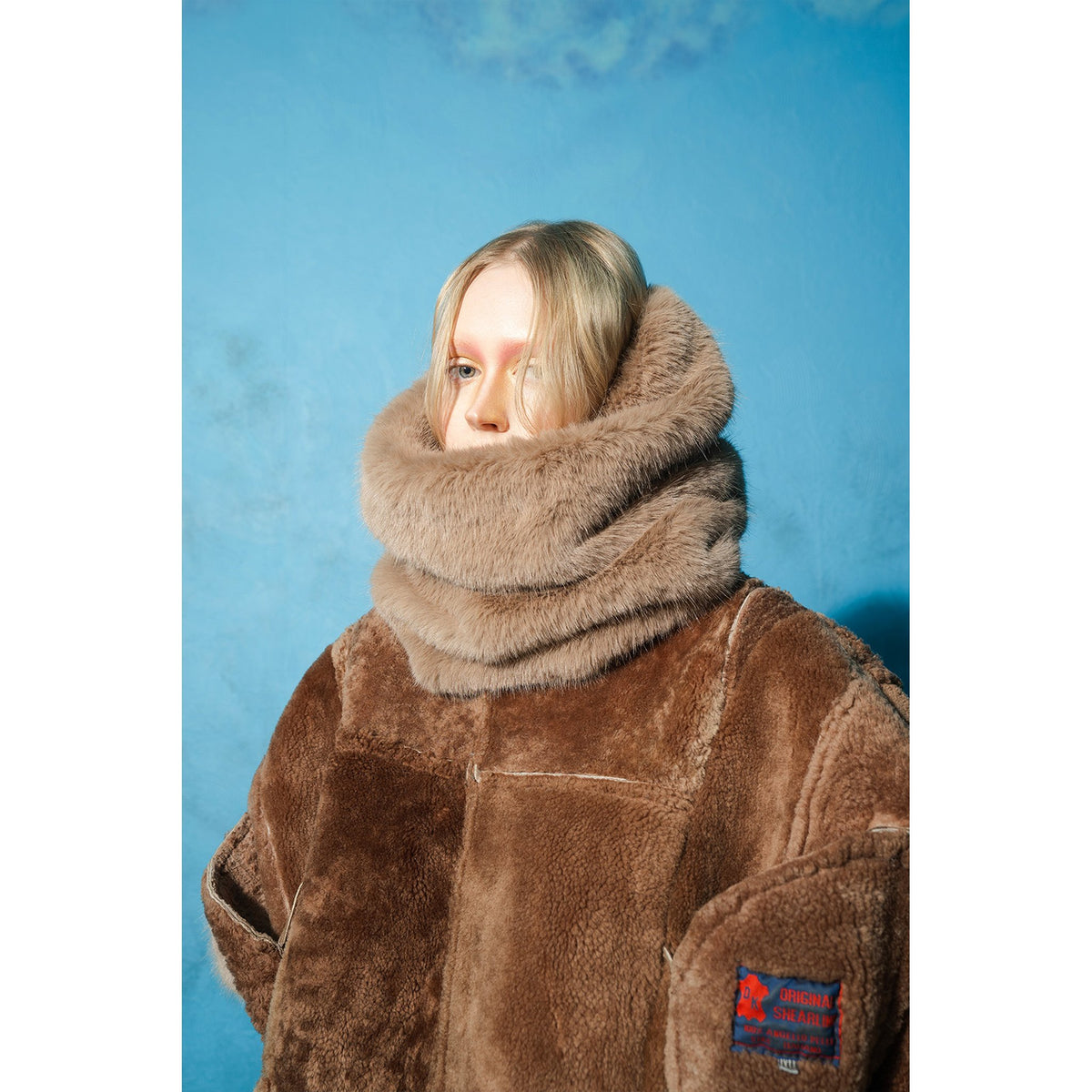 Model wearing brown and mint reversible faux fur jacket by MASHAT