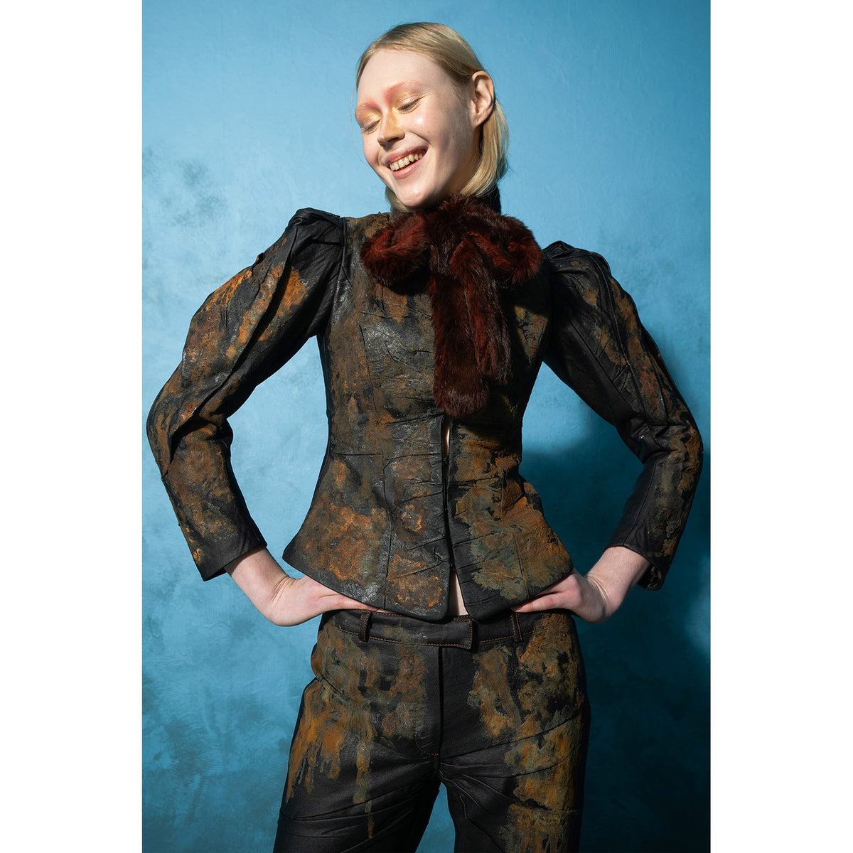 Model wearing black rust-effect faux leather blazer with gigot sleeves