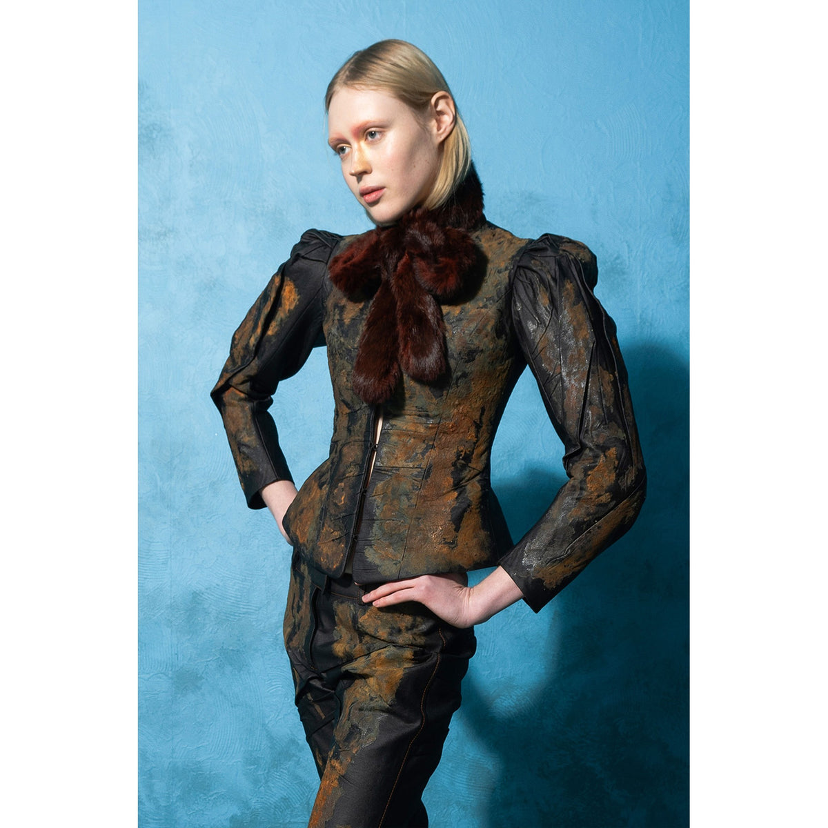 Model wearing black rust-effect faux leather blazer with gigot sleeves