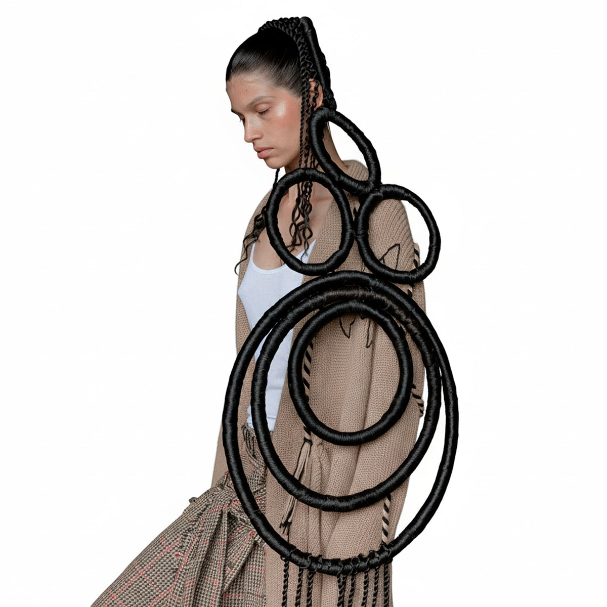 Woman holding a large black hair extension against a white background