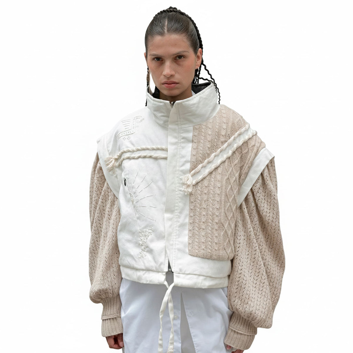 Person wearing a beige and white jacket with a white background