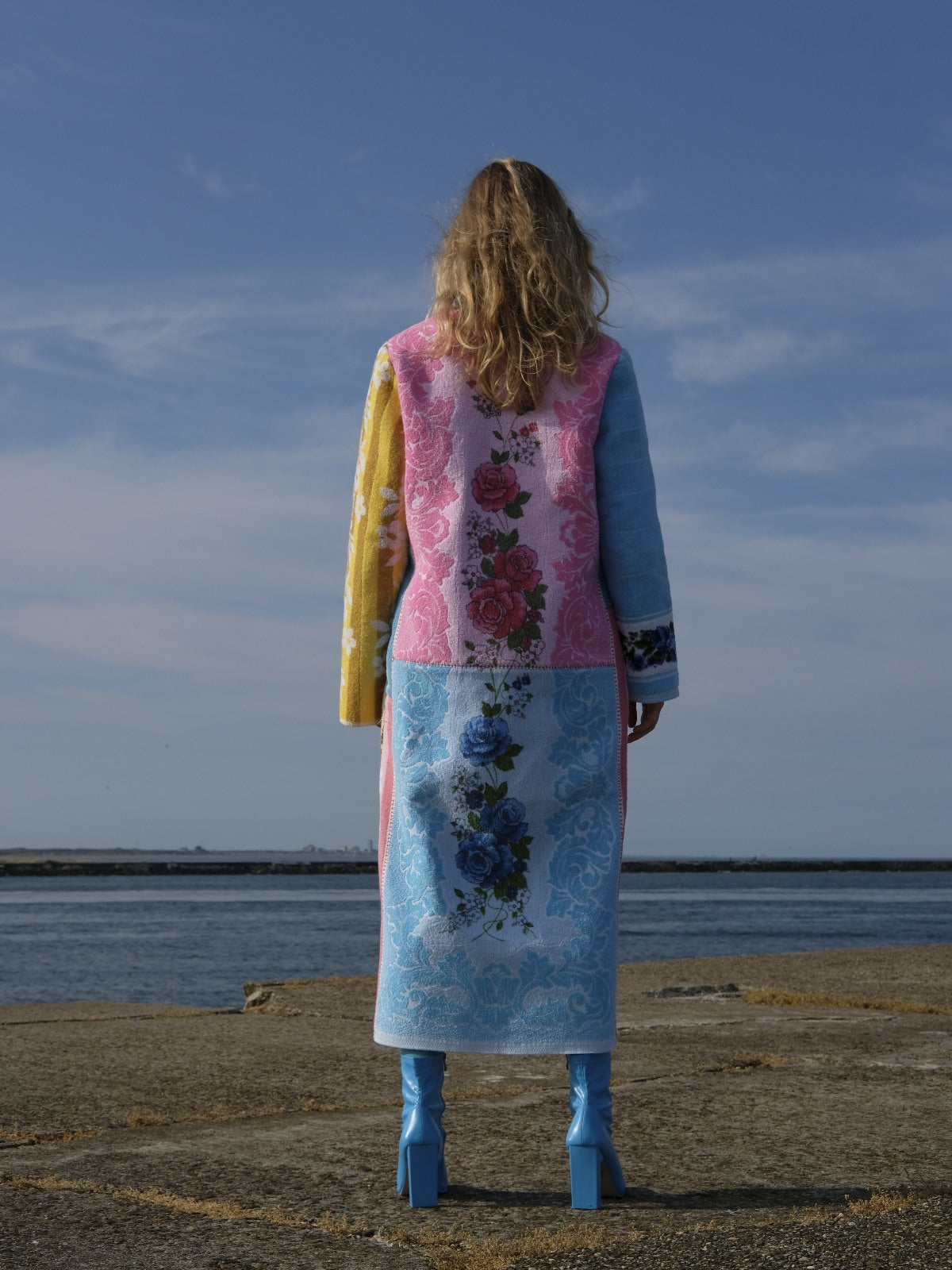 STUDIO WUNDERBAR Long Lunes Martes Coat: multicolor floral patchwork long coat with sunshine yellow florals, electric blue accents, pink and blue rose panels and vintage children illustrations, upcycled one-of-a-kind coat, worn by model, buy at DOORS NYC
