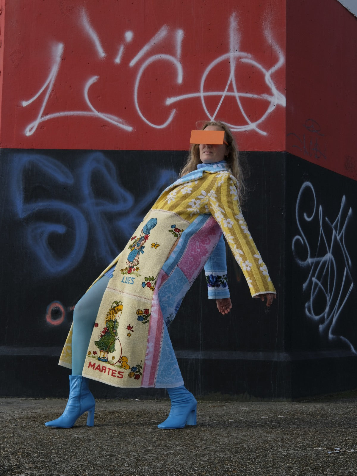 STUDIO WUNDERBAR Long Lunes Martes Coat: multicolor floral patchwork long coat with sunshine yellow florals, electric blue accents, pink and blue rose panels and vintage children illustrations, upcycled one-of-a-kind coat, worn by model, buy at DOORS NYC