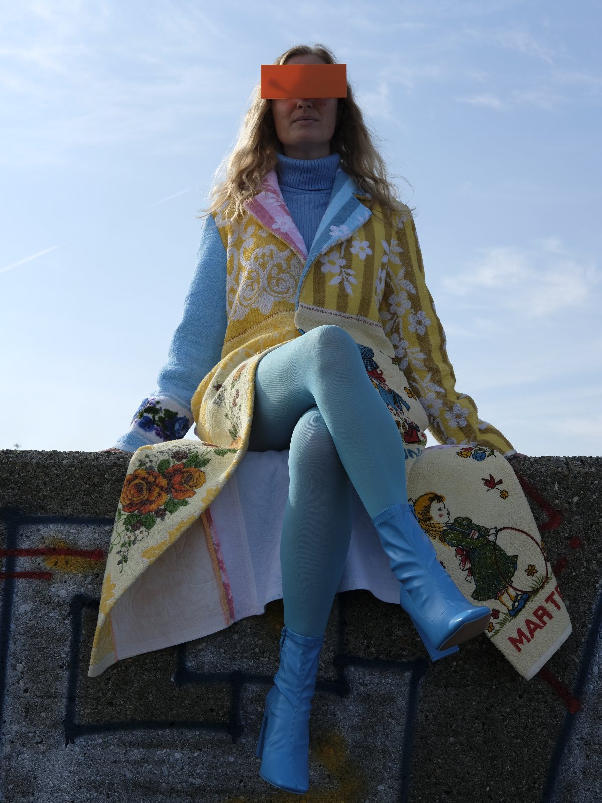STUDIO WUNDERBAR Long Lunes Martes Coat: multicolor floral patchwork long coat with sunshine yellow florals, electric blue accents, pink and blue rose panels and vintage children illustrations, upcycled one-of-a-kind coat, worn by model, buy at DOORS NYC