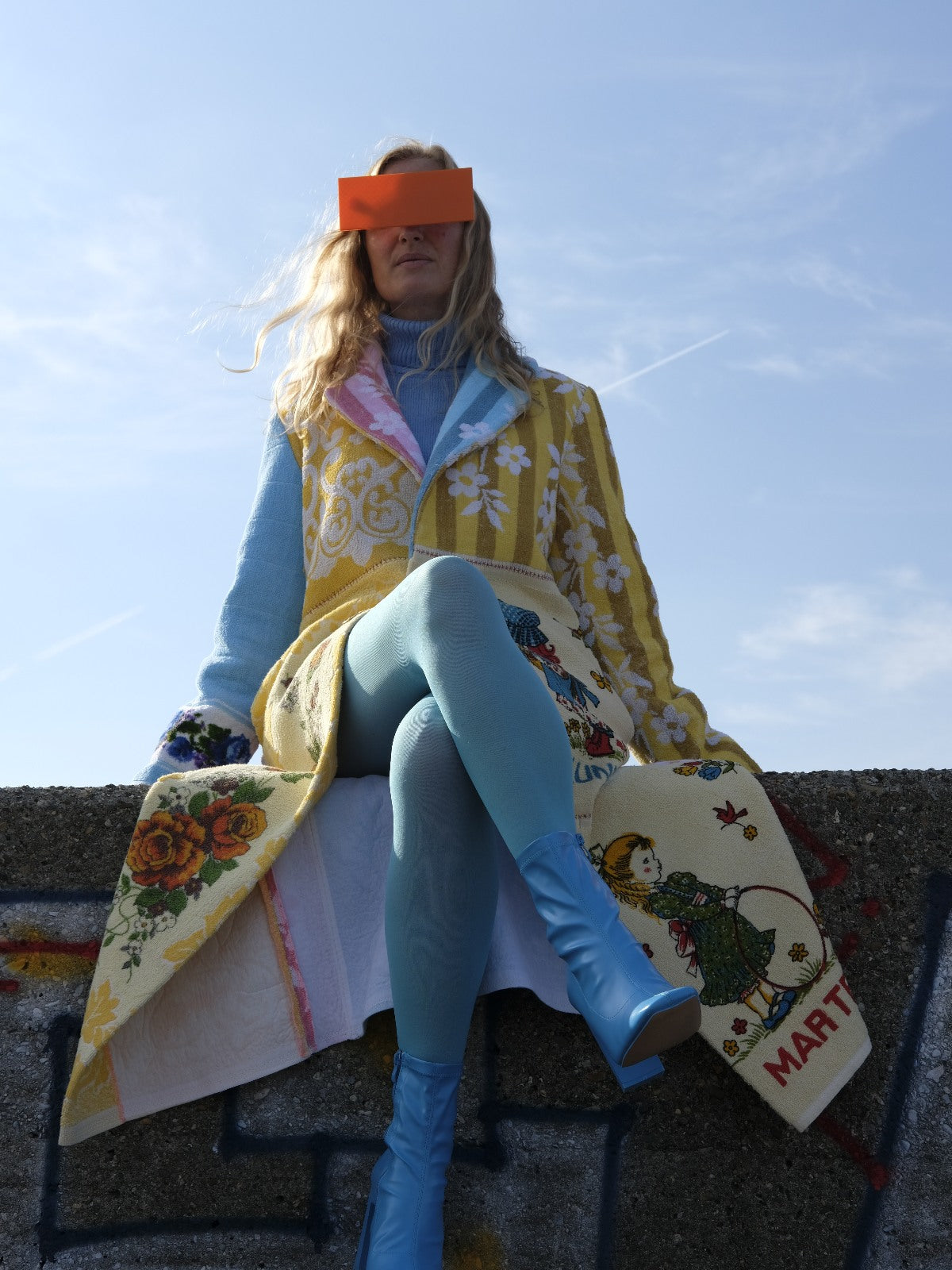 STUDIO WUNDERBAR Long Lunes Martes Coat: multicolor floral patchwork long coat with sunshine yellow florals, electric blue accents, pink and blue rose panels and vintage children illustrations, upcycled one-of-a-kind coat, worn by model, buy at DOORS NYC