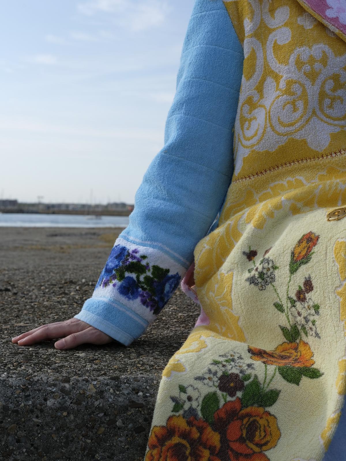 STUDIO WUNDERBAR Long Lunes Martes Coat: multicolor floral patchwork long coat with sunshine yellow florals, electric blue accents, pink and blue rose panels and vintage children illustrations, upcycled one-of-a-kind coat, worn by model, buy at DOORS NYC