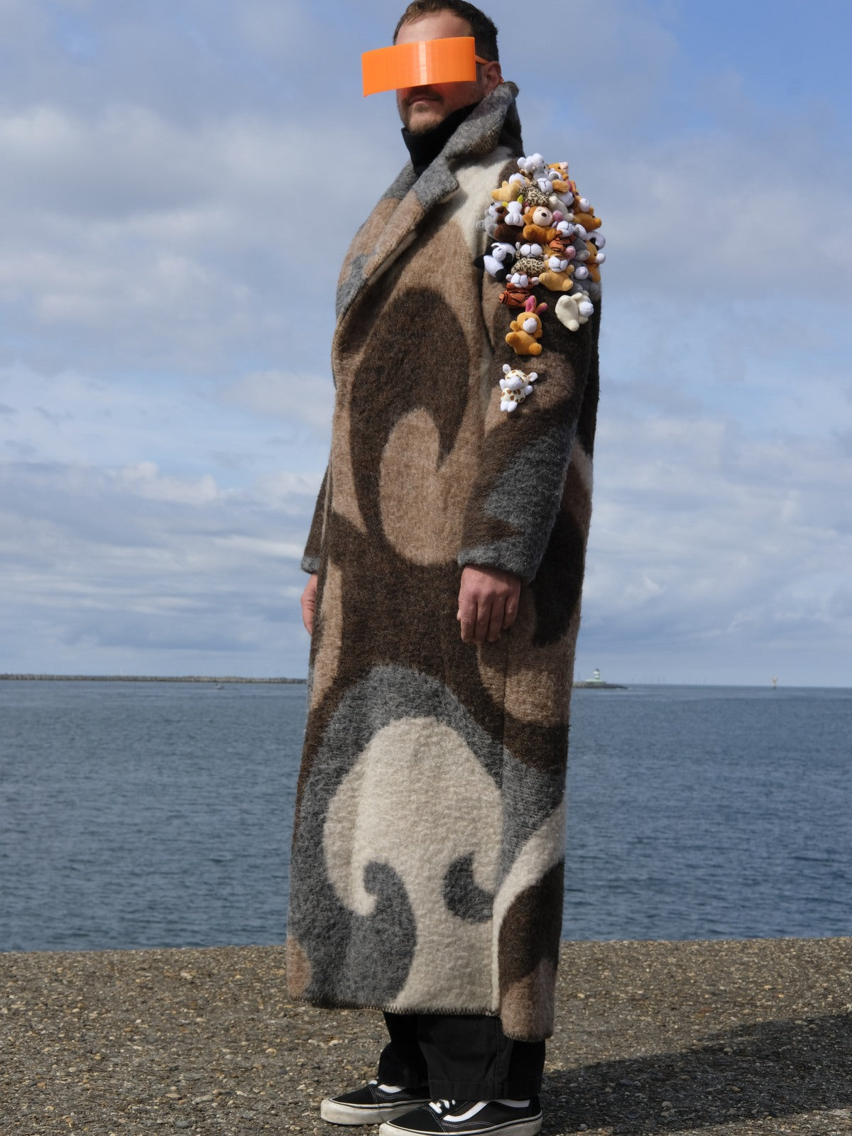STUDIO WUNDERBAR Brown Cuddly Shoulder Coat: brown and cream retro swirl long coat with plush toys on the shoulder, upcycled one-of-a-kind coat, worn by model, buy at DOORS NYC