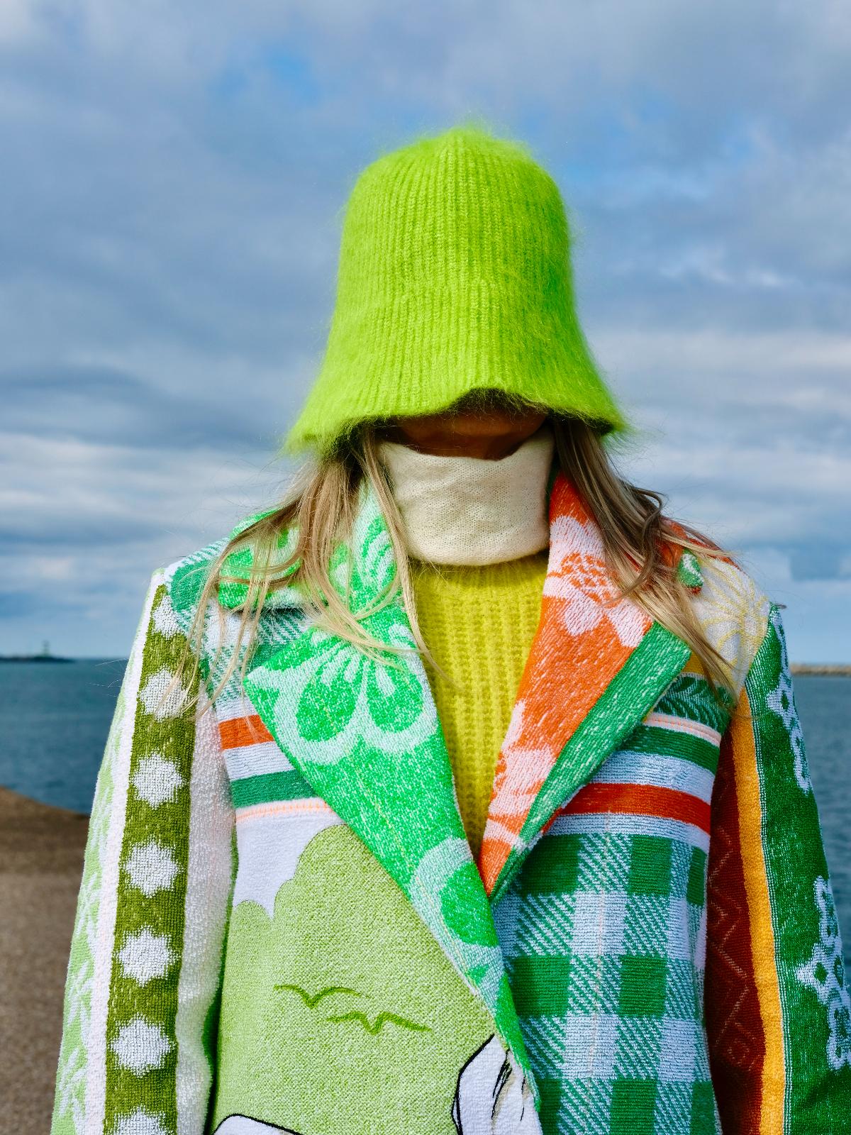 STUDIO WUNDERBAR Mouse With Big Ears Coat: green and orange patchwork long coat with gingham checks, floral motifs and a Mickey Mouse storybook panel, upcycled one-of-a-kind coat, worn by model, buy at DOORS NYC