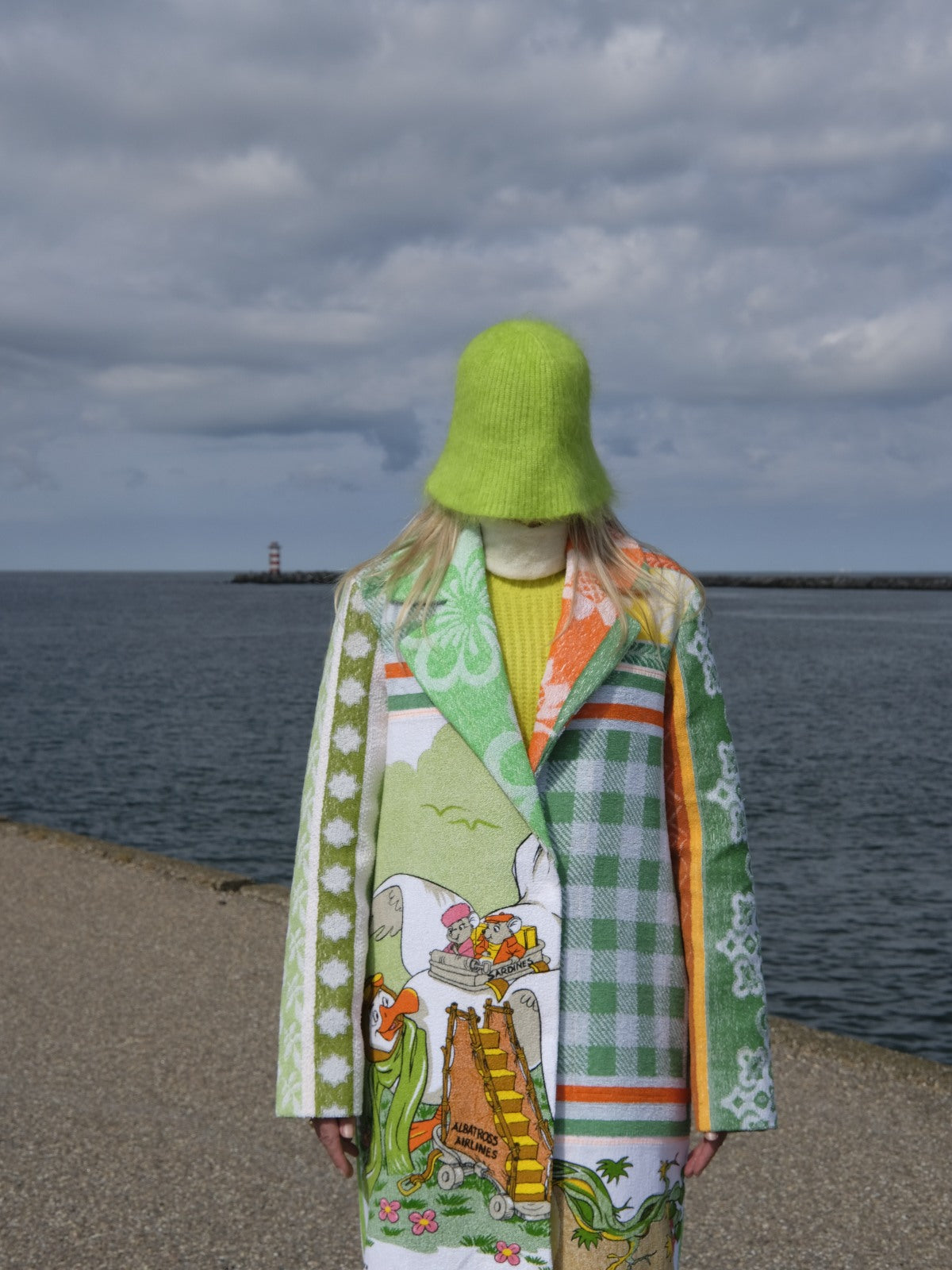 STUDIO WUNDERBAR Mouse With Big Ears Coat: green and orange patchwork long coat with gingham checks, floral motifs and a Mickey Mouse storybook panel, upcycled one-of-a-kind coat, close-up detail, buy at DOORS NYC