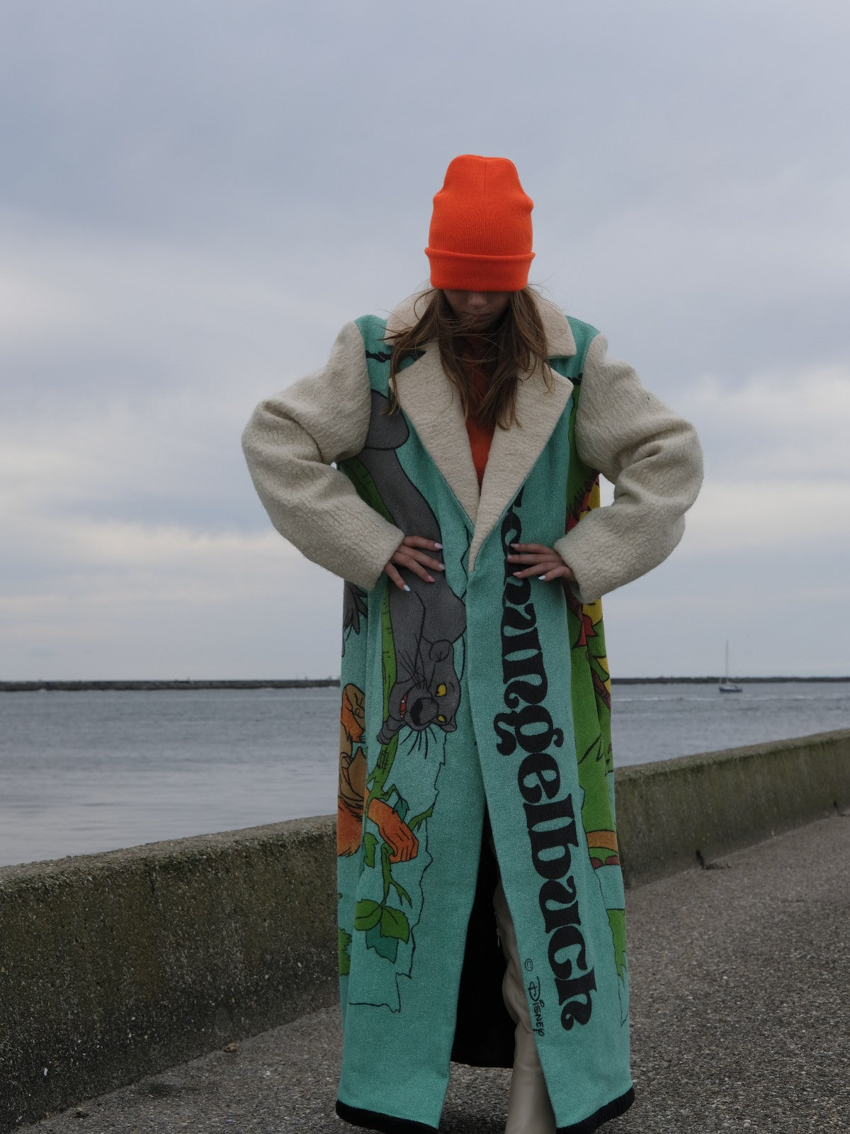 STUDIO WUNDERBAR Jungle Book Coat: turquoise graphic long coat with a Bagheera panther illustration from The Jungle Book and cream sleeves, upcycled one-of-a-kind coat, worn by model, buy at DOORS NYC