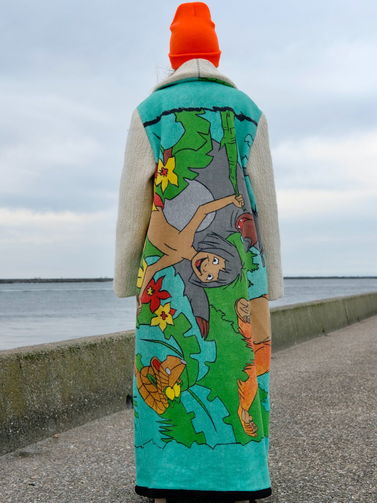 STUDIO WUNDERBAR Jungle Book Coat: turquoise graphic long coat with a Bagheera panther illustration from The Jungle Book and cream sleeves, upcycled one-of-a-kind coat, worn by model, buy at DOORS NYC