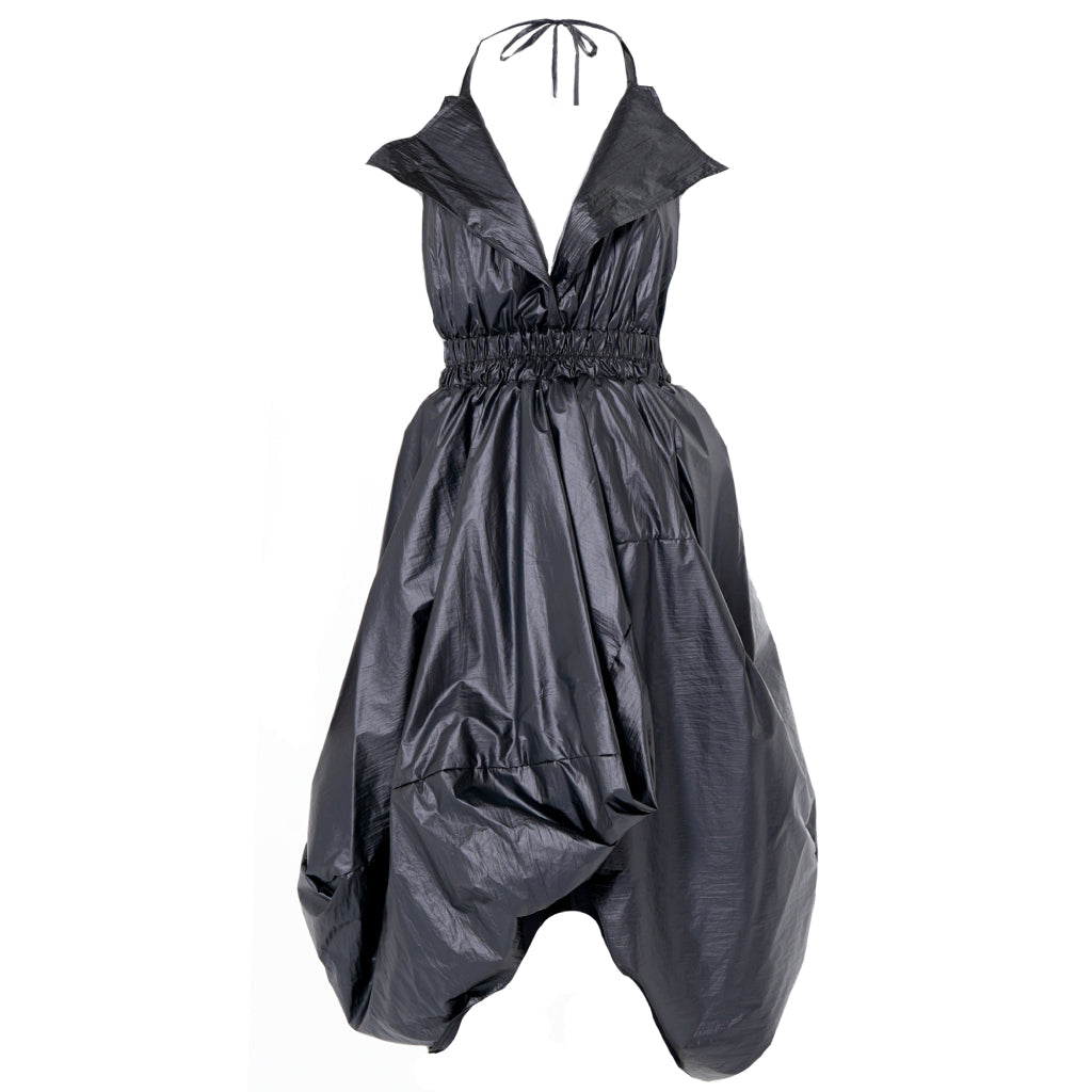 The Draped Balloon Pinafore Dress in Black by METAMORPHOZA features a shiny halter neckline, deep V-neck, ruched waist, voluminous balloon silhouette, and a slightly crinkled texture.