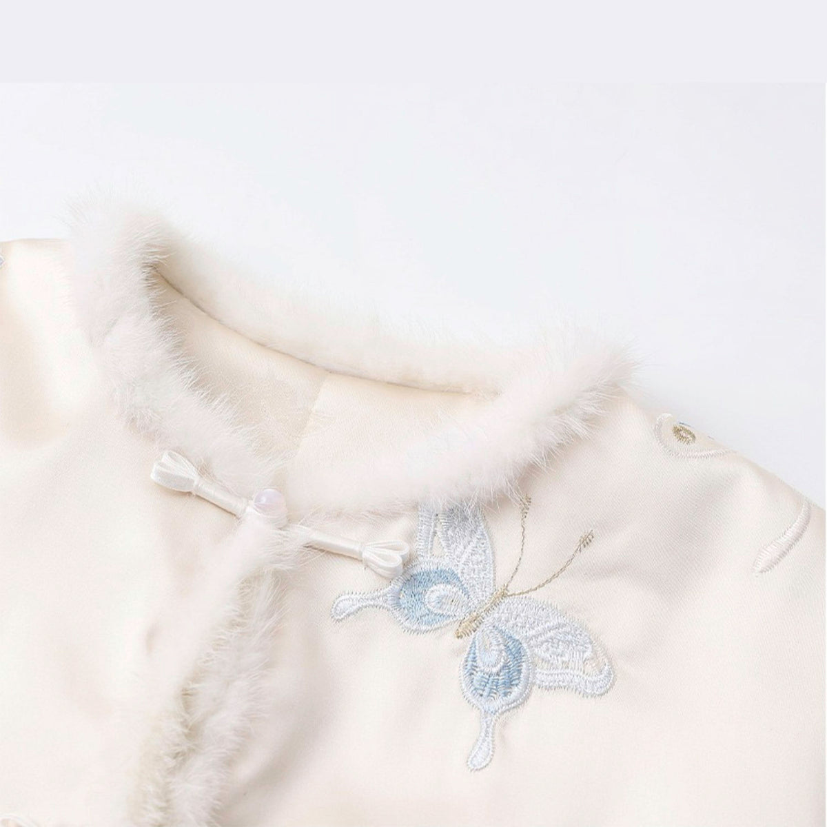 White garment with butterfly embroidery on a white background