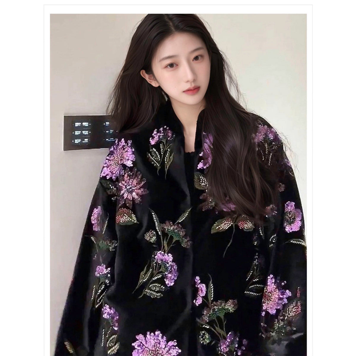 Woman wearing a black floral embroidered garment against a neutral background