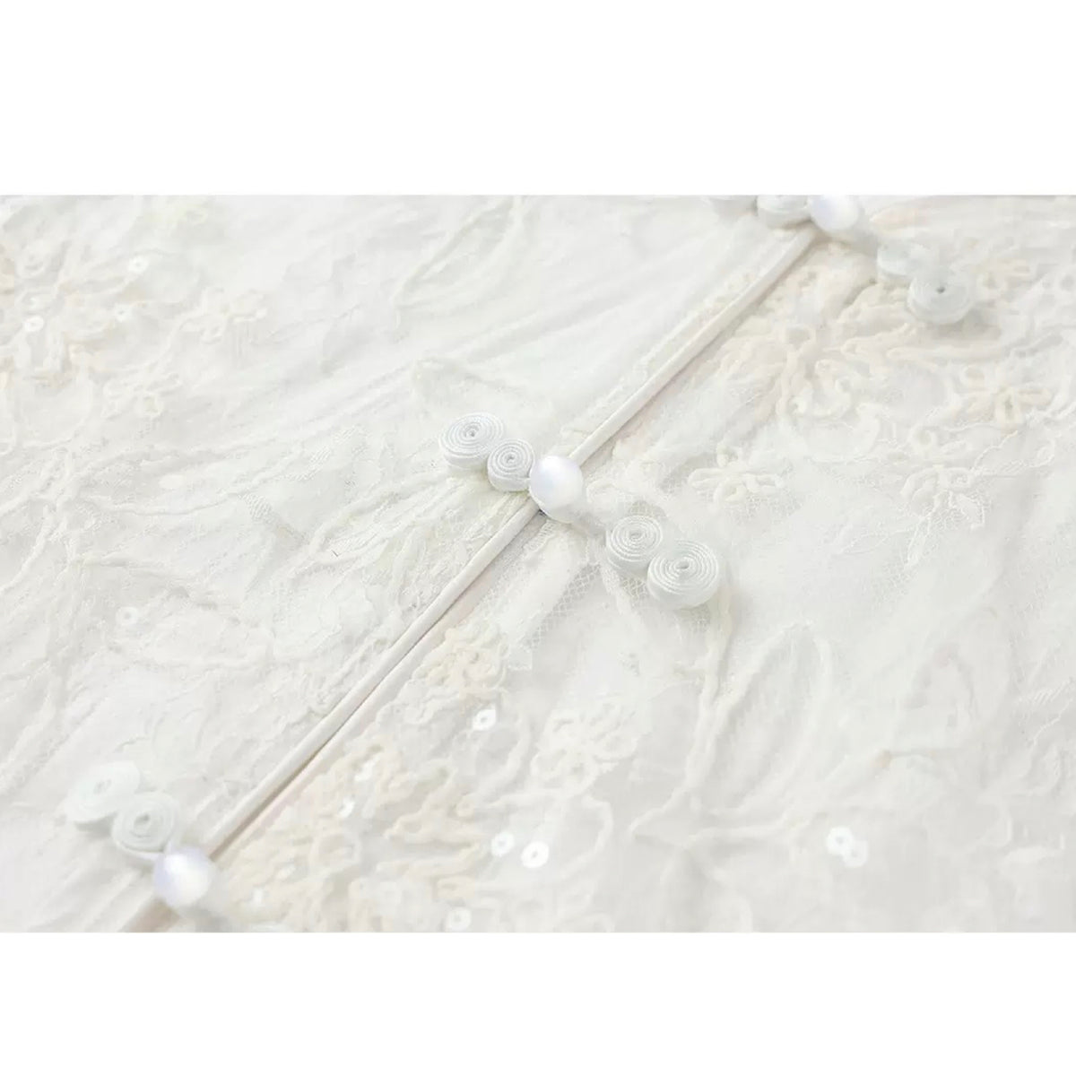 Close-up of a textured white fabric with pearl-like beads.