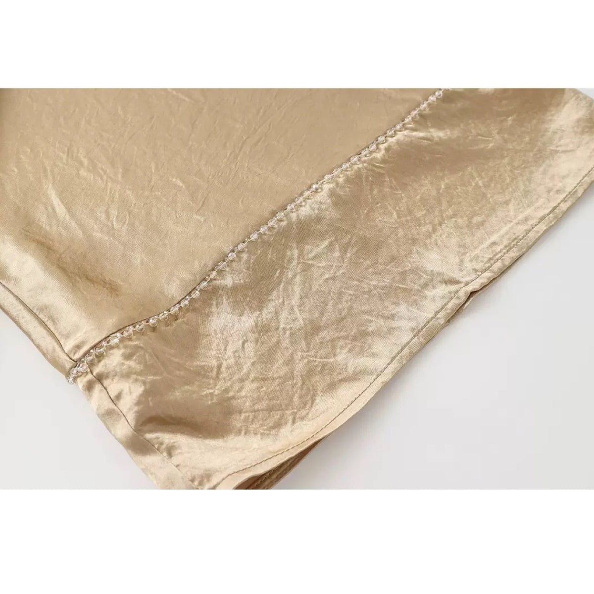 Gold metallic fabric on a white background