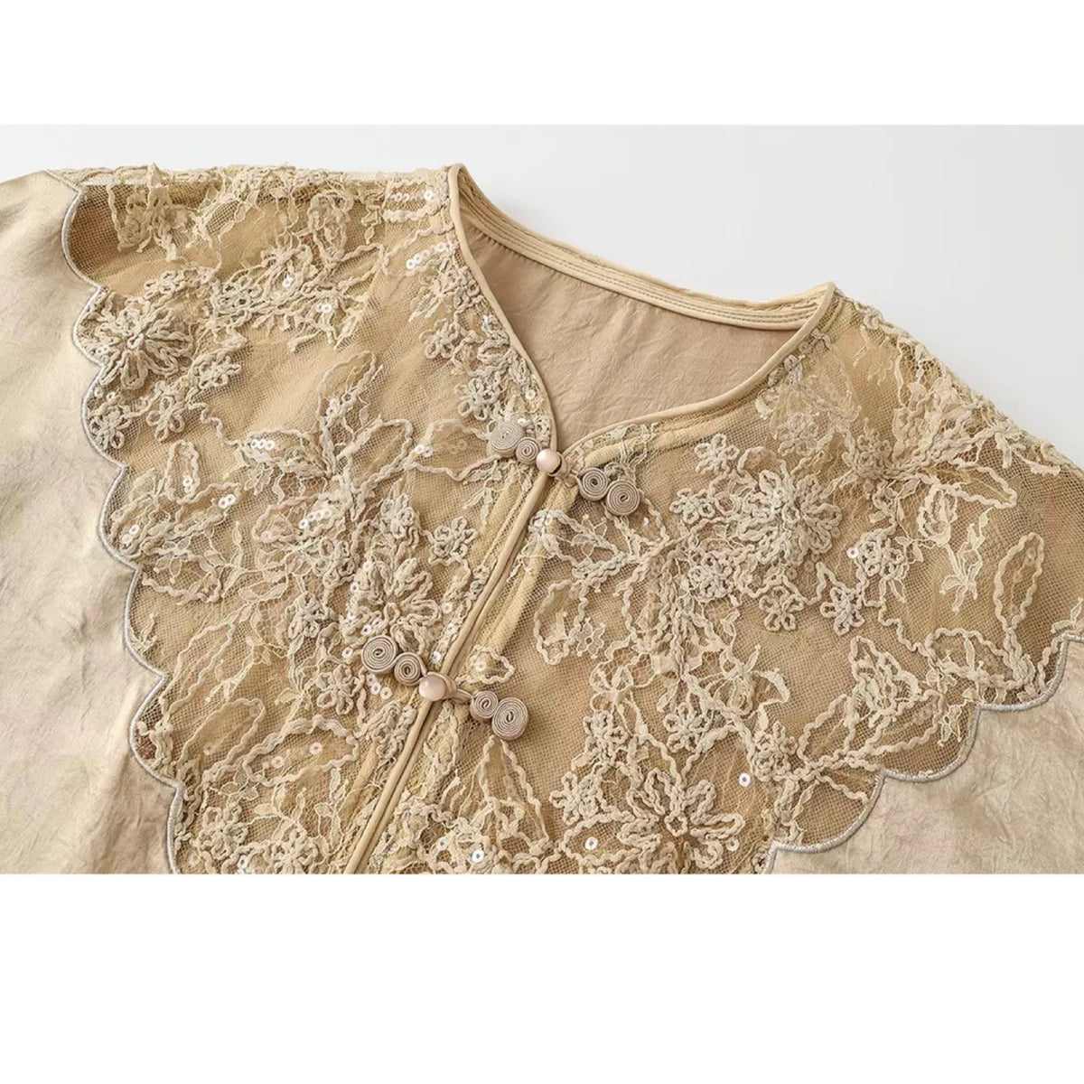 Beige lace top with floral patterns on a white background