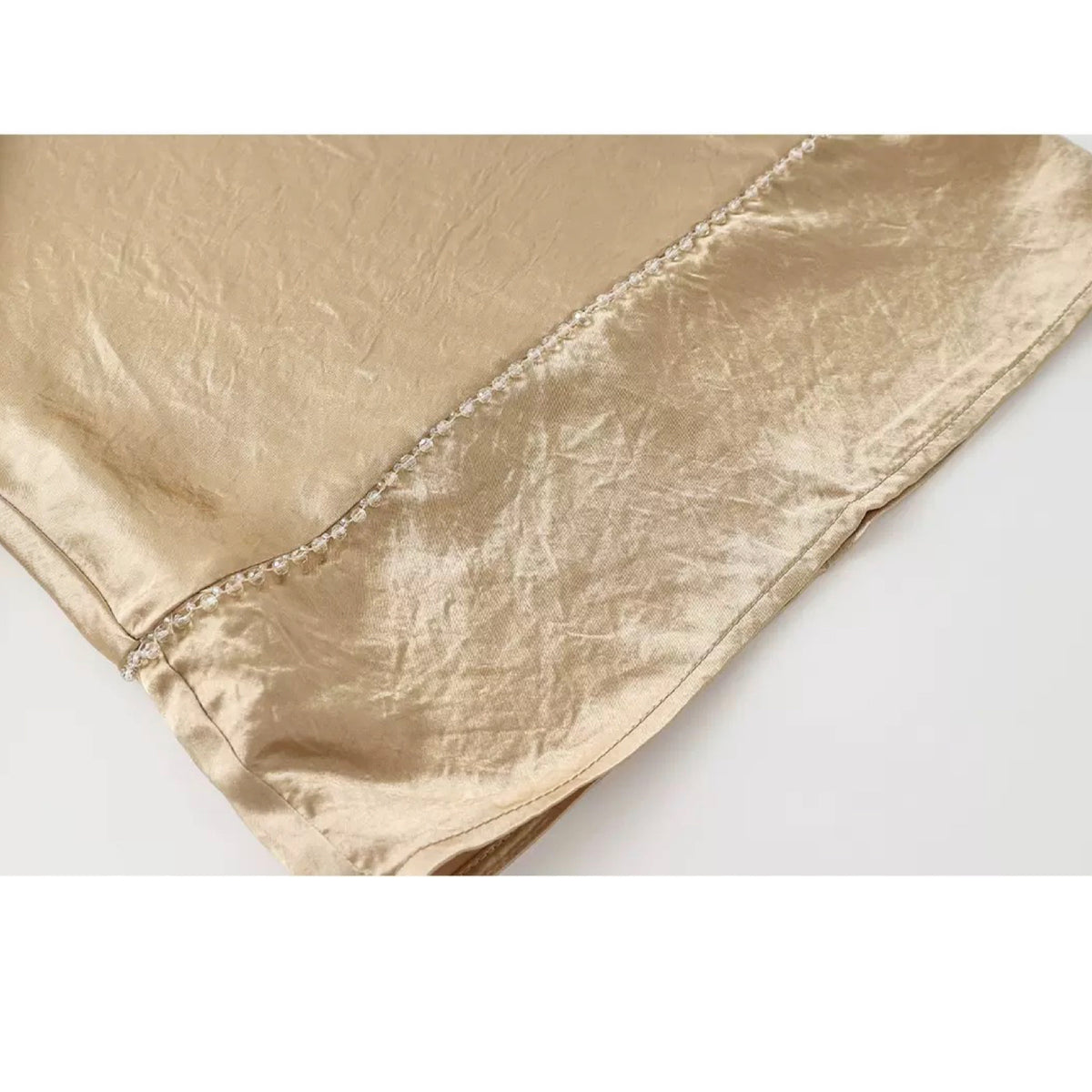 Gold satin fabric on a white background