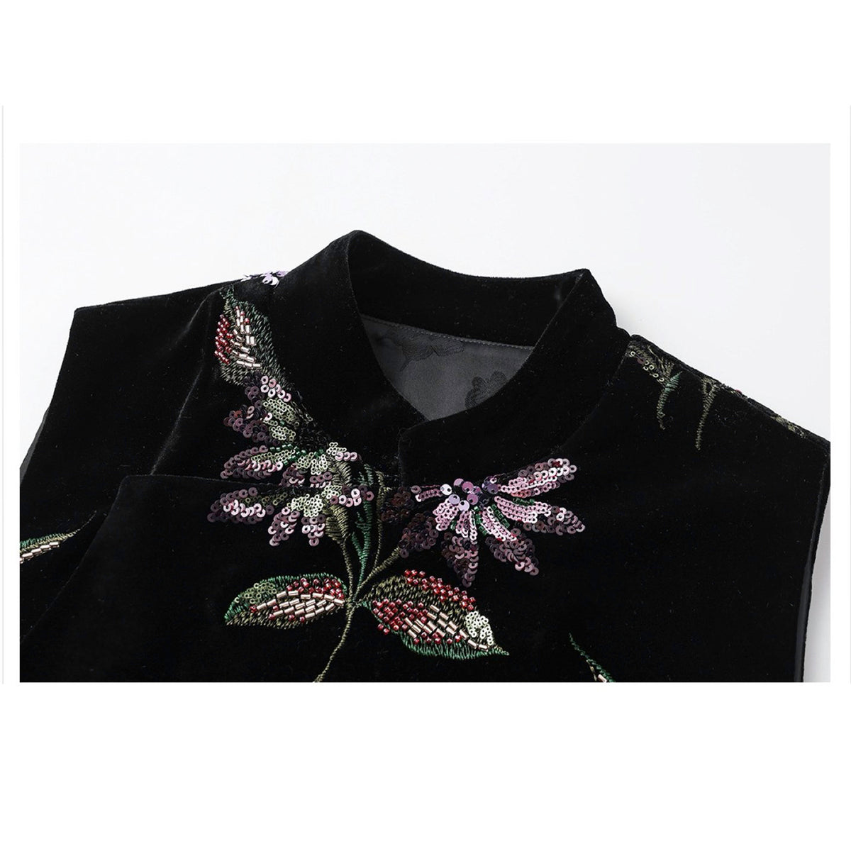 Black blouse with floral embroidery on a white background