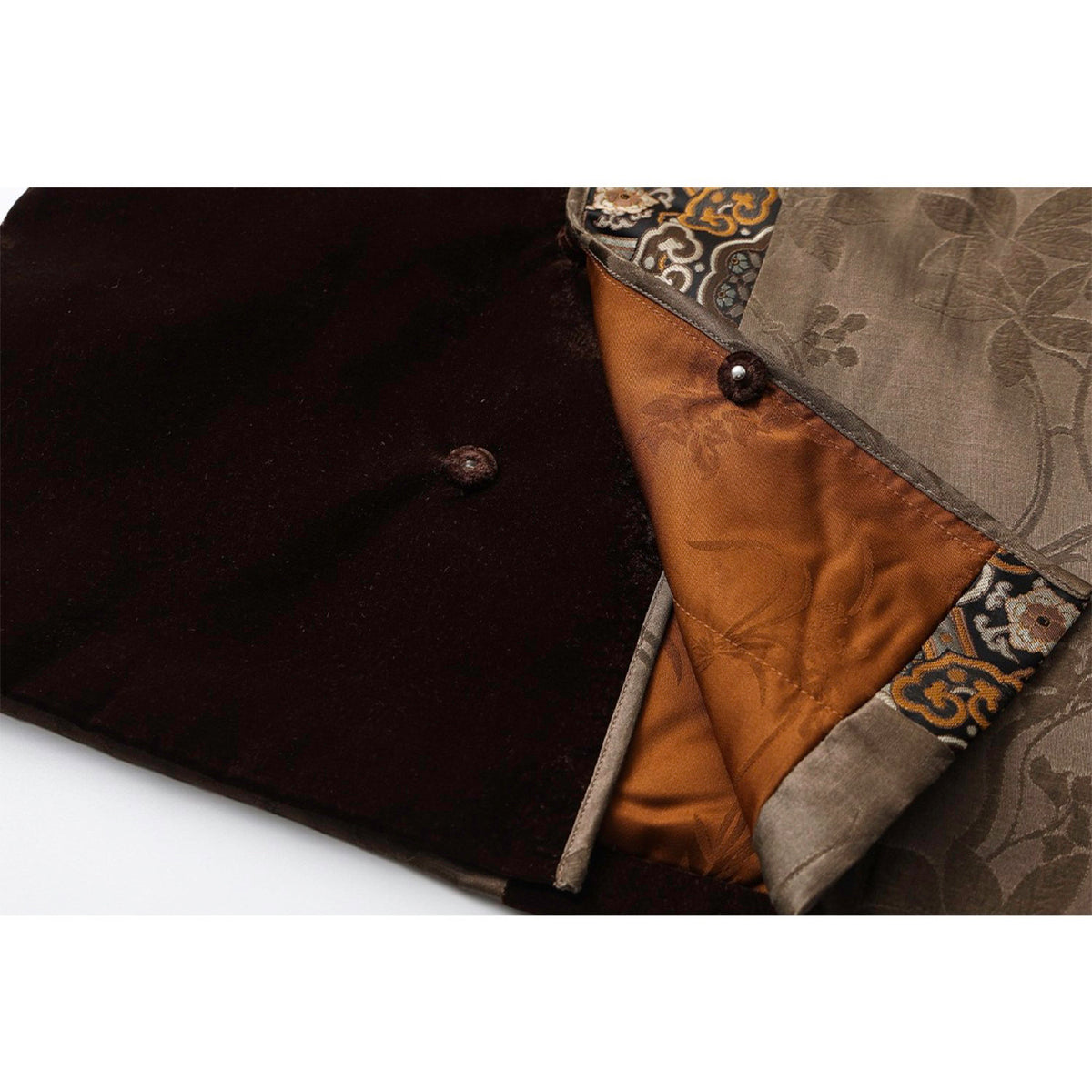 Close-up of a black garment with floral embroidery and a button, on a white background.