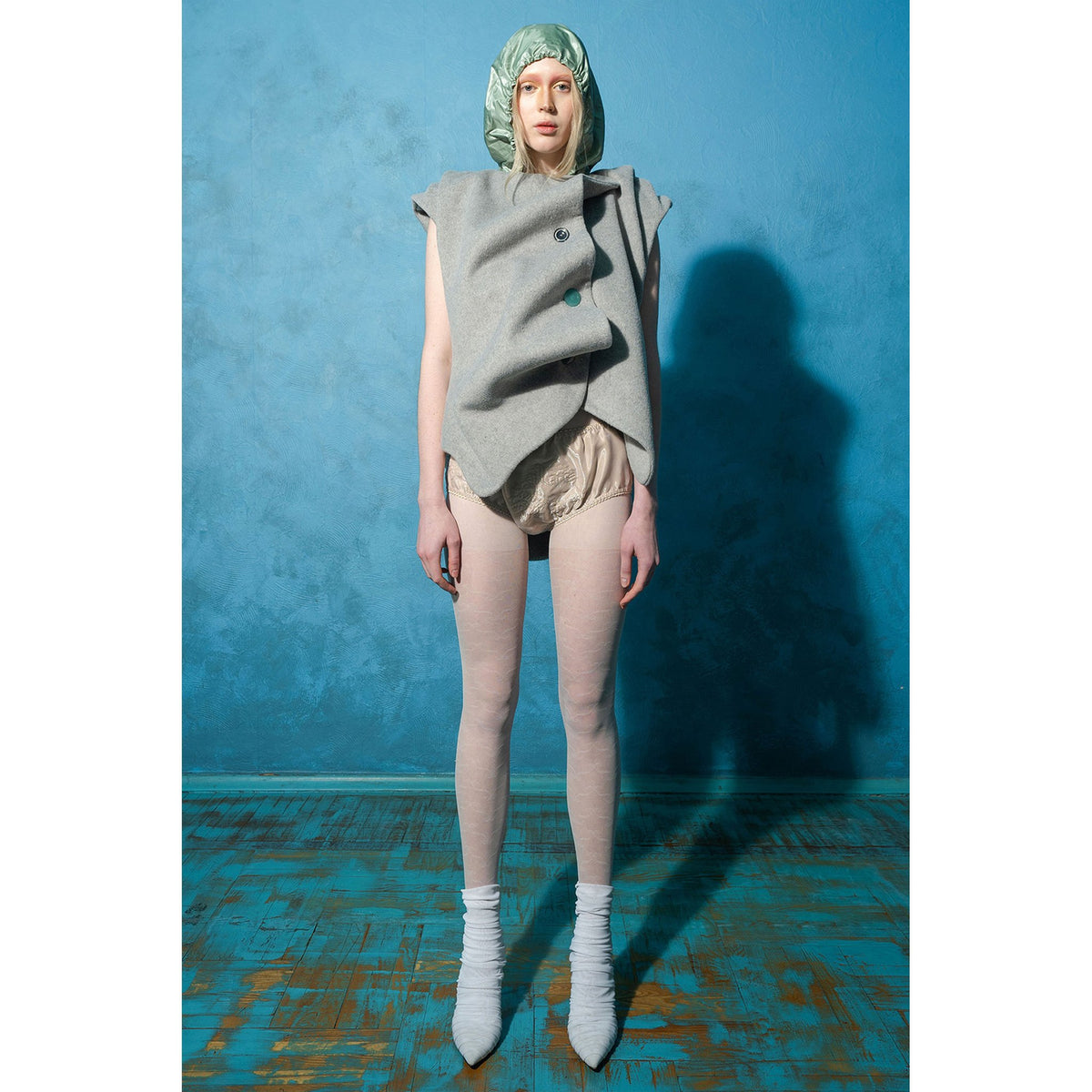 Model wearing grey wavy ruched wool-blend vest with vintage buttons by MASHAT