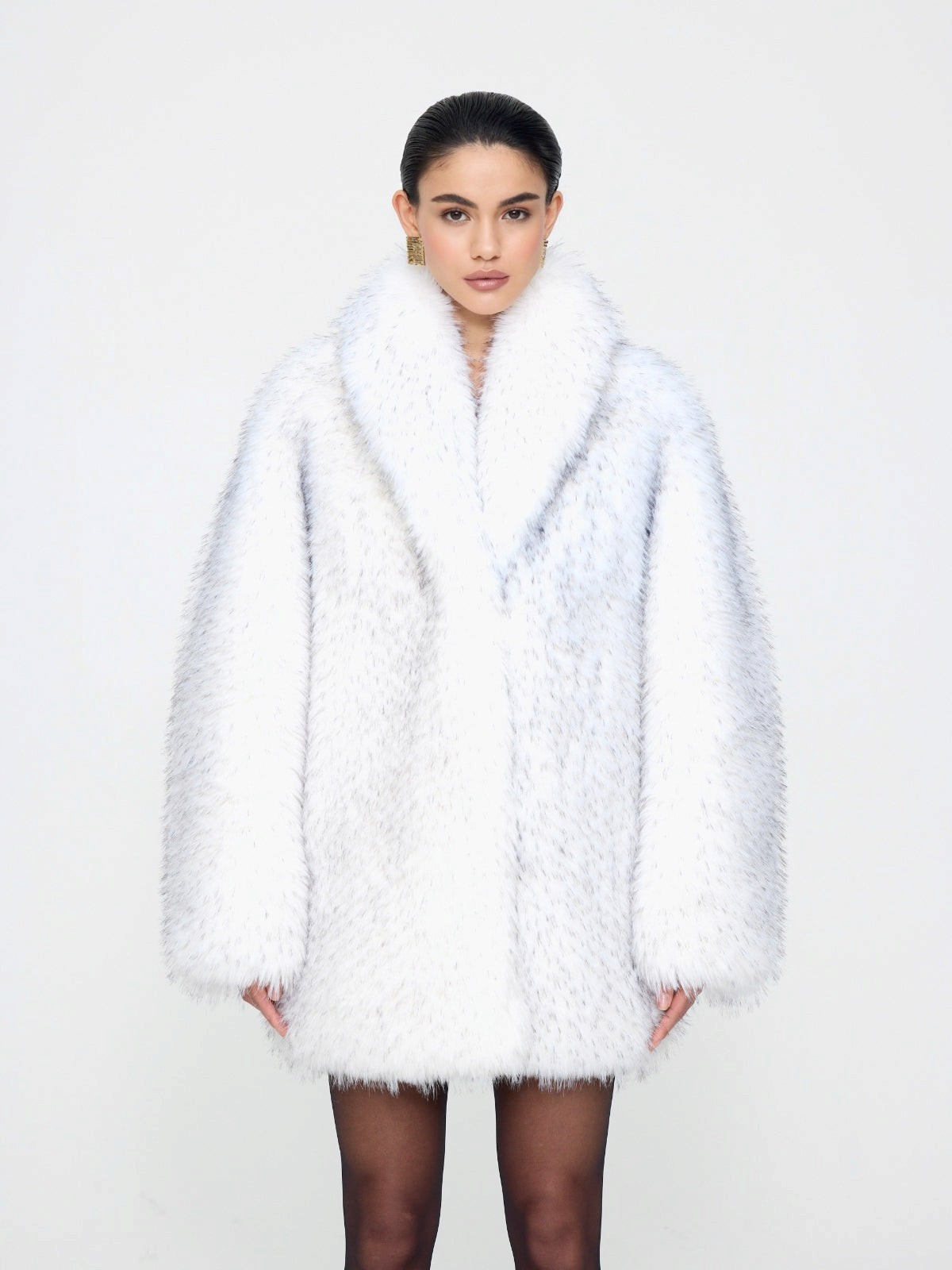 Manteau oversized en fausse fourrure blanche Elsa de doors.nyc avec des pointes noires, coupe droite et luxueuse.