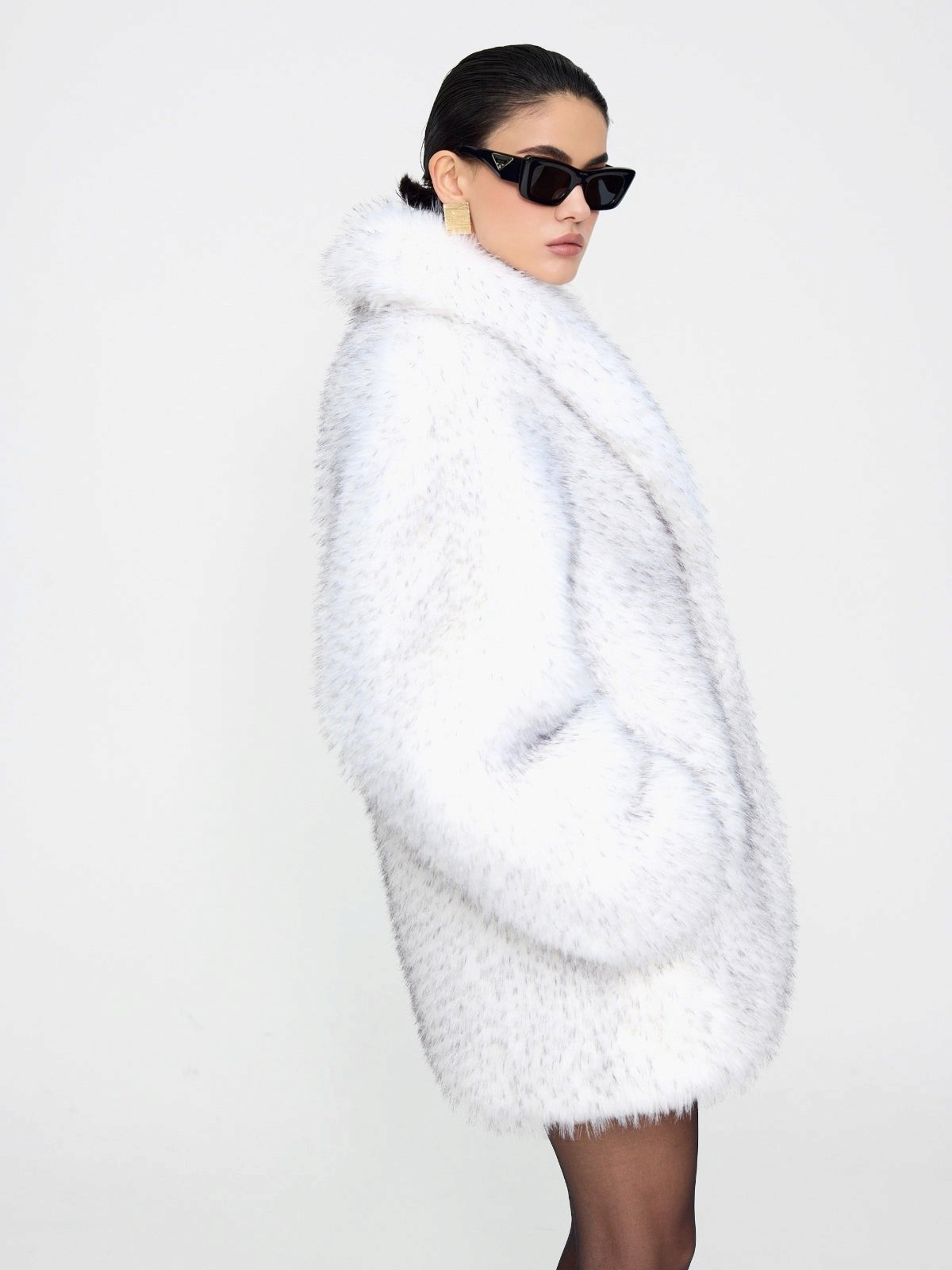 Manteau oversized en fausse fourrure blanche Elsa de doors.nyc avec pointes noires, porté par un mannequin.